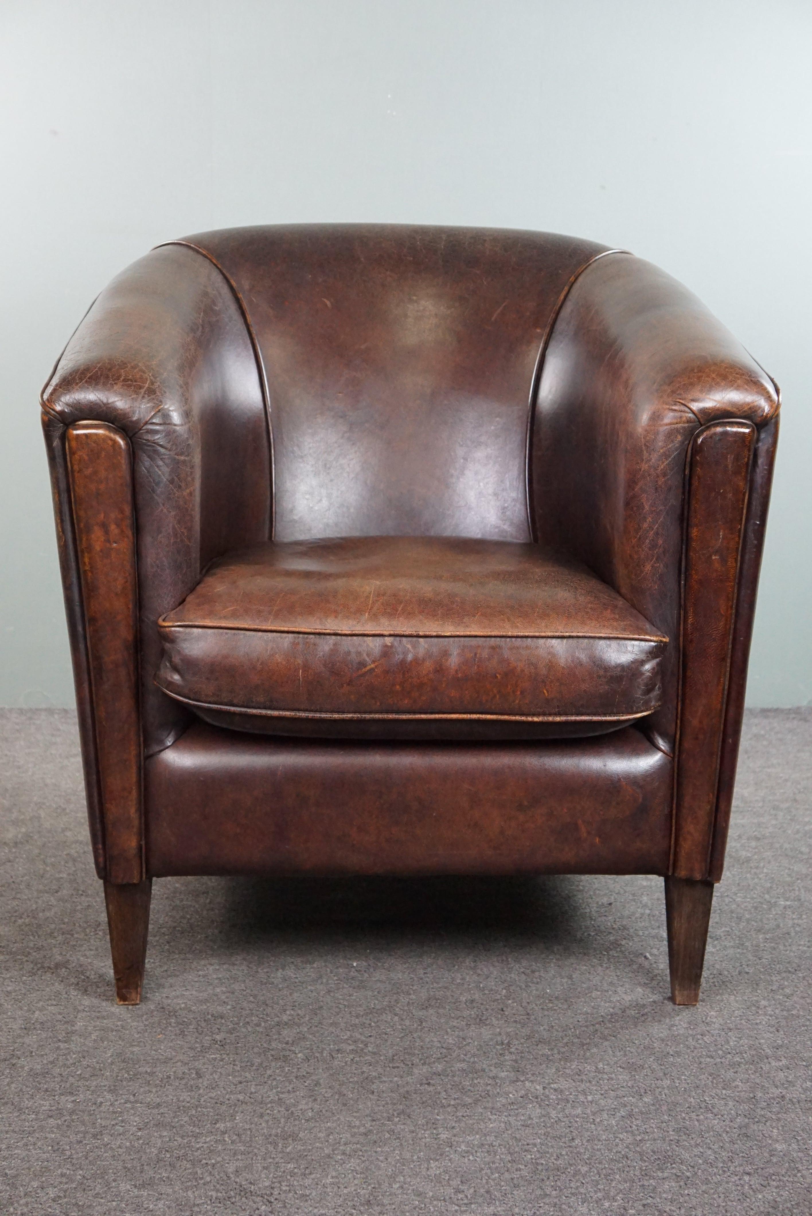 Te ofrecemos este sillón club de piel de cordero oscura con un diseño elegante.

Este precioso sillón club de diseño en piel de cordero oscura tiene un toque Art Déco que lo hace algo más emocionante que un sillón club 