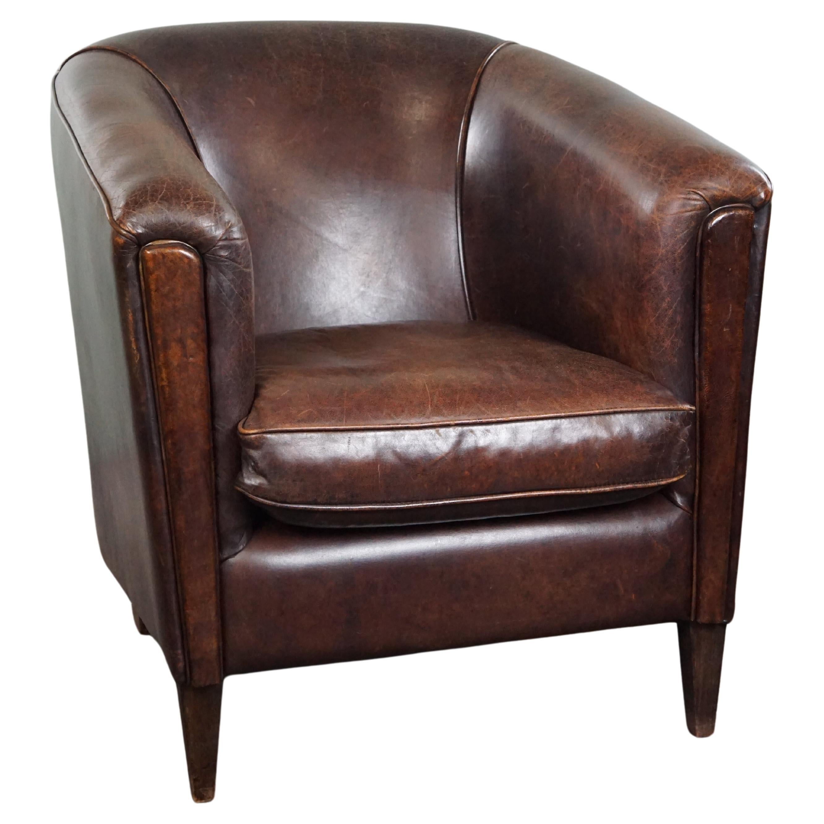 Fauteuil club en cuir de mouton foncé, design élégant