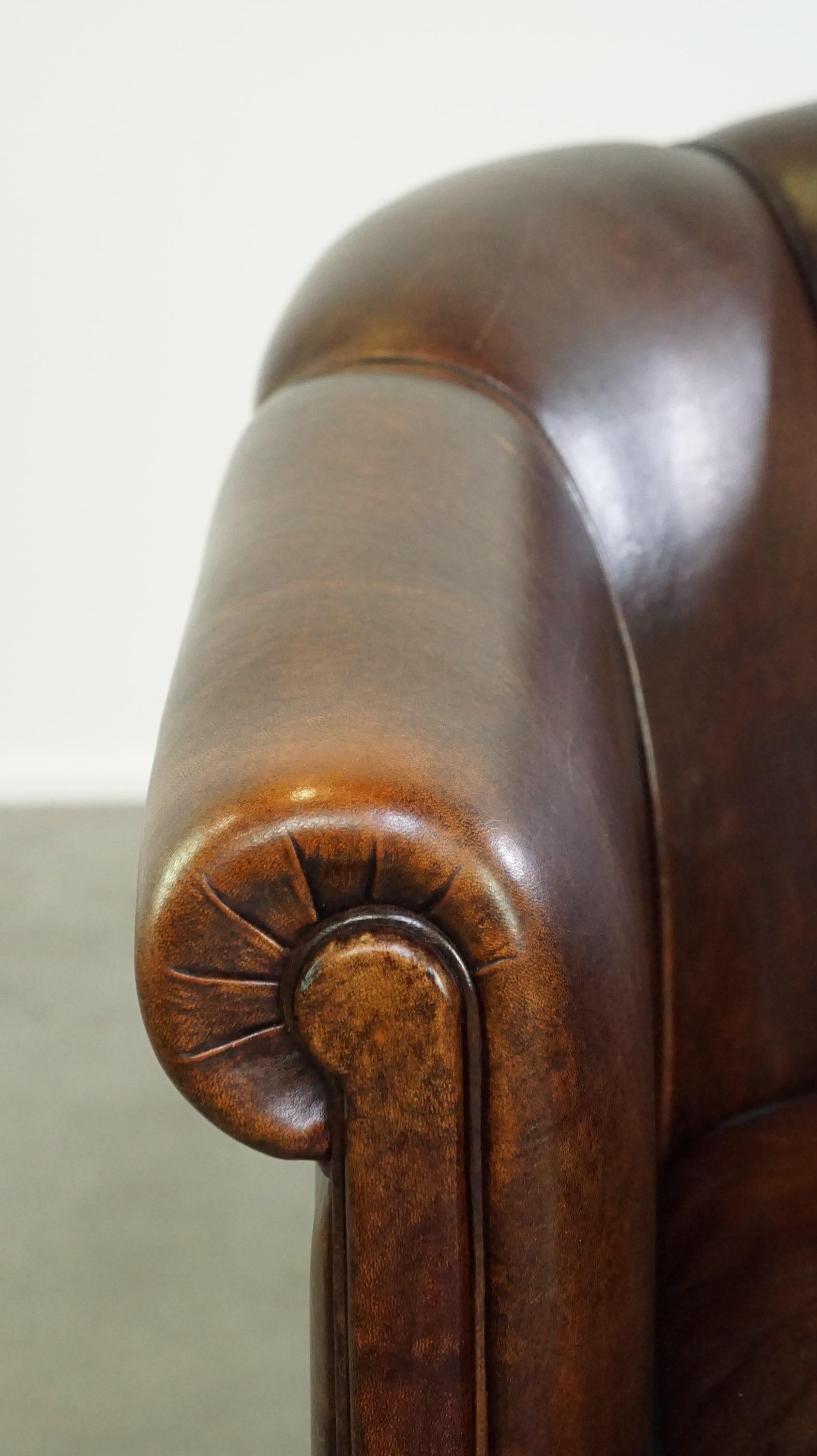 Dark sheep leather club chair with uniquely shaped armrests For Sale 4