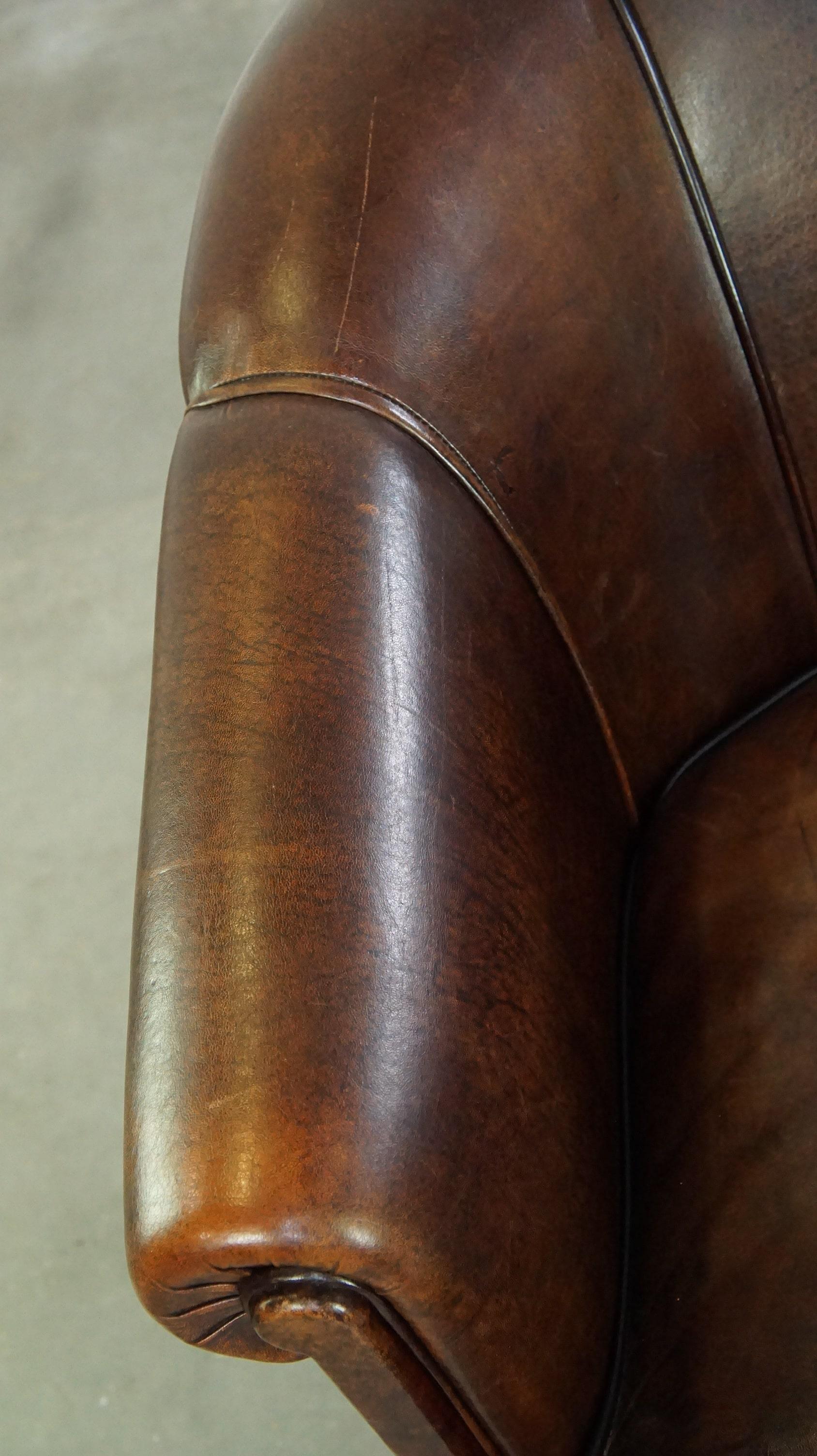 Dark sheep leather club chair with uniquely shaped armrests For Sale 1