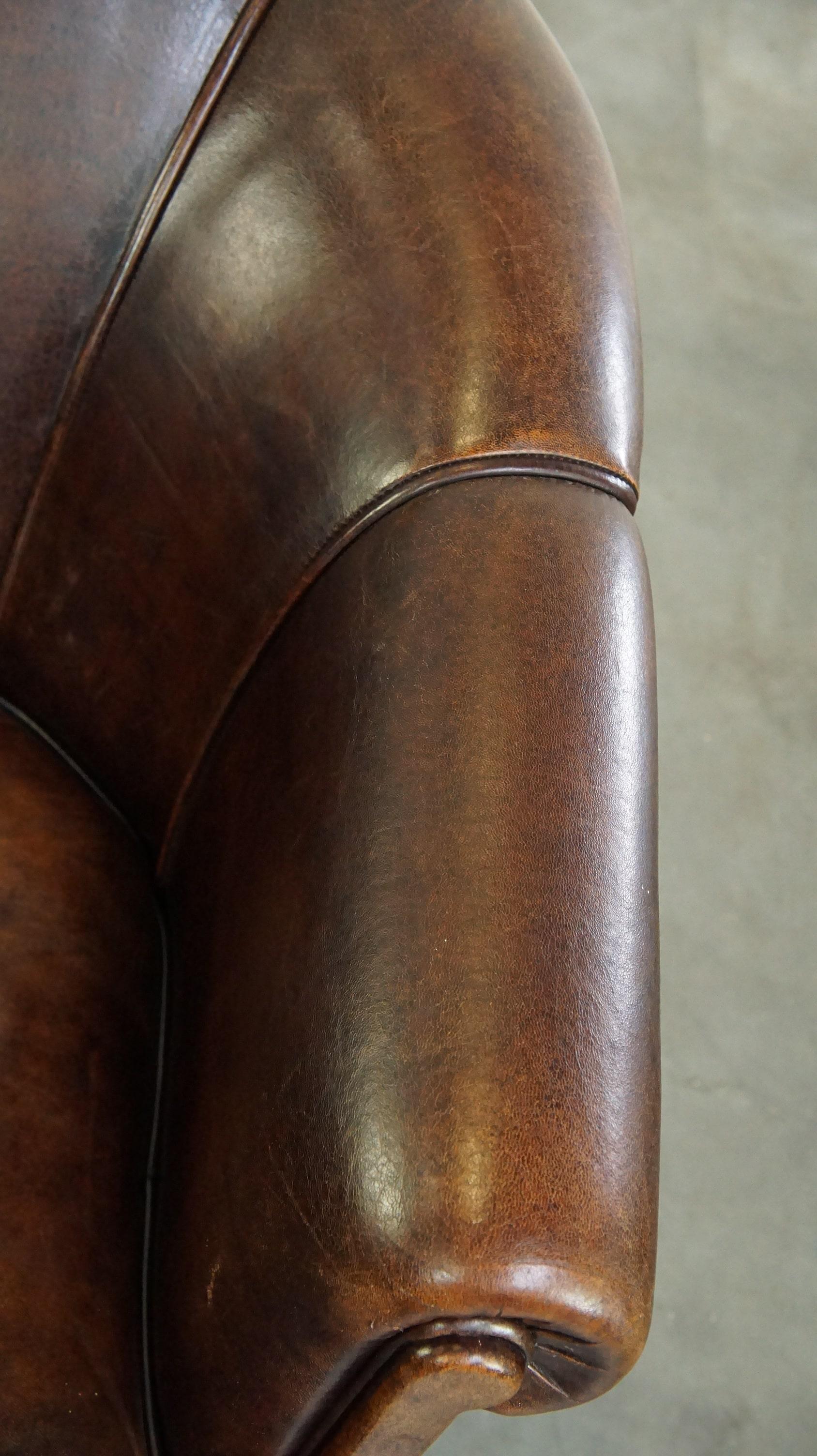 Dark sheep leather club chair with uniquely shaped armrests For Sale 2