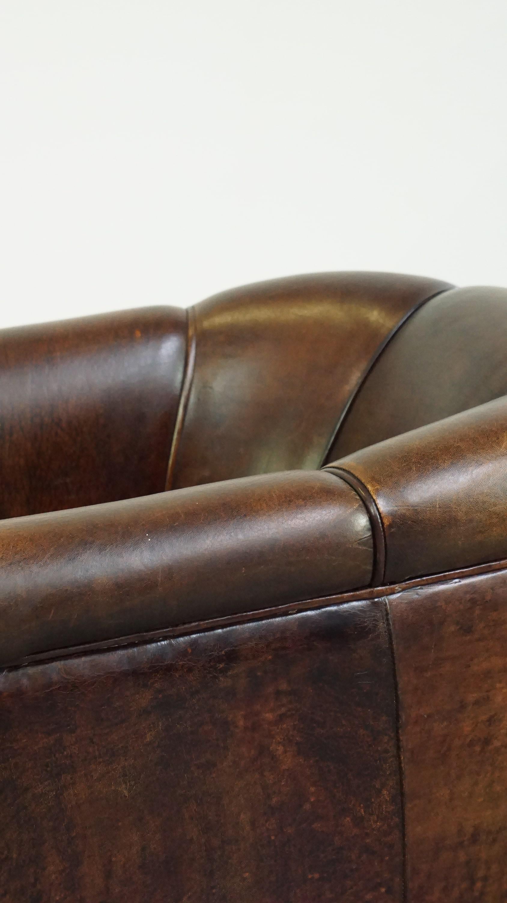 Dark sheep leather club chair with uniquely shaped armrests For Sale 3