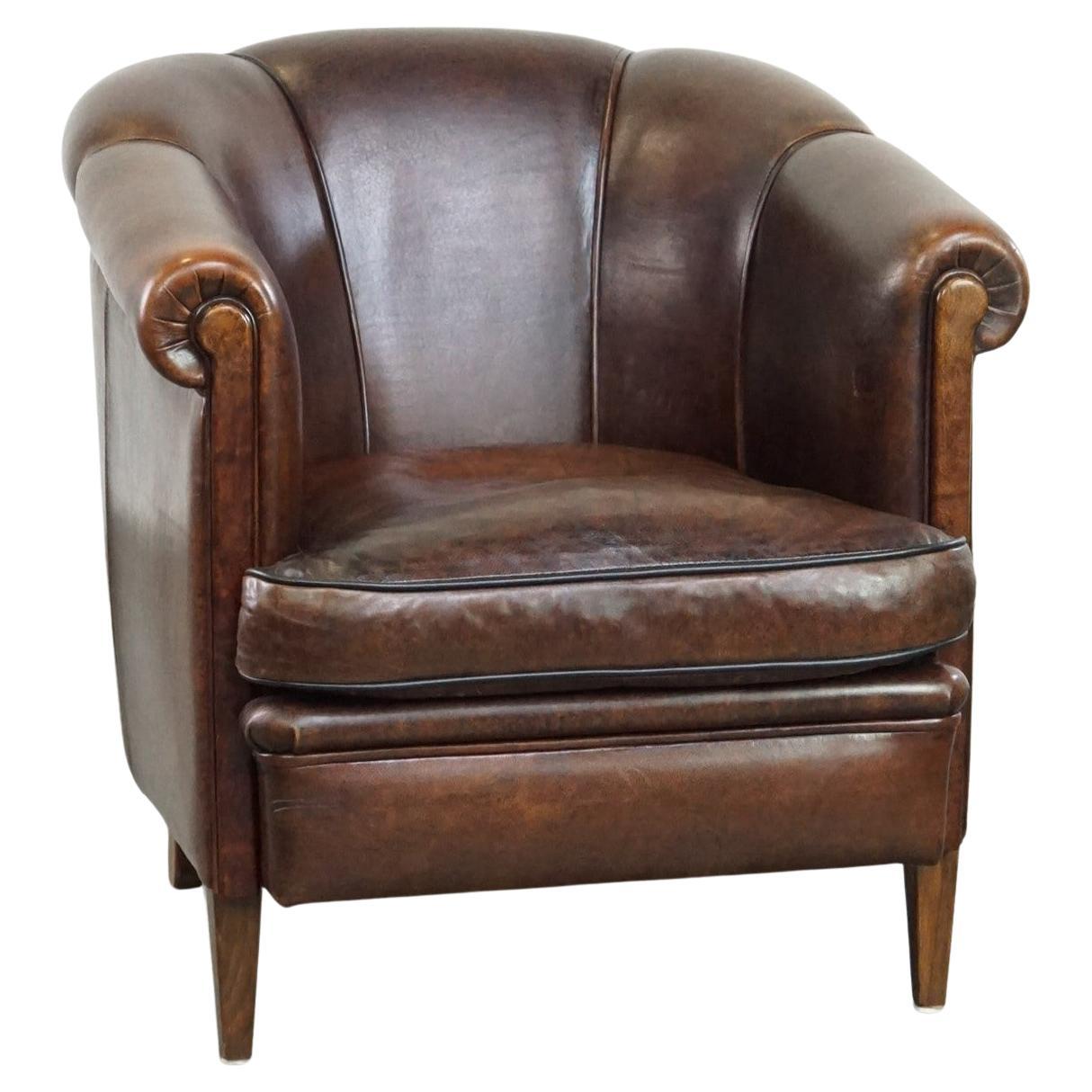 Dark sheep leather club chair with uniquely shaped armrests