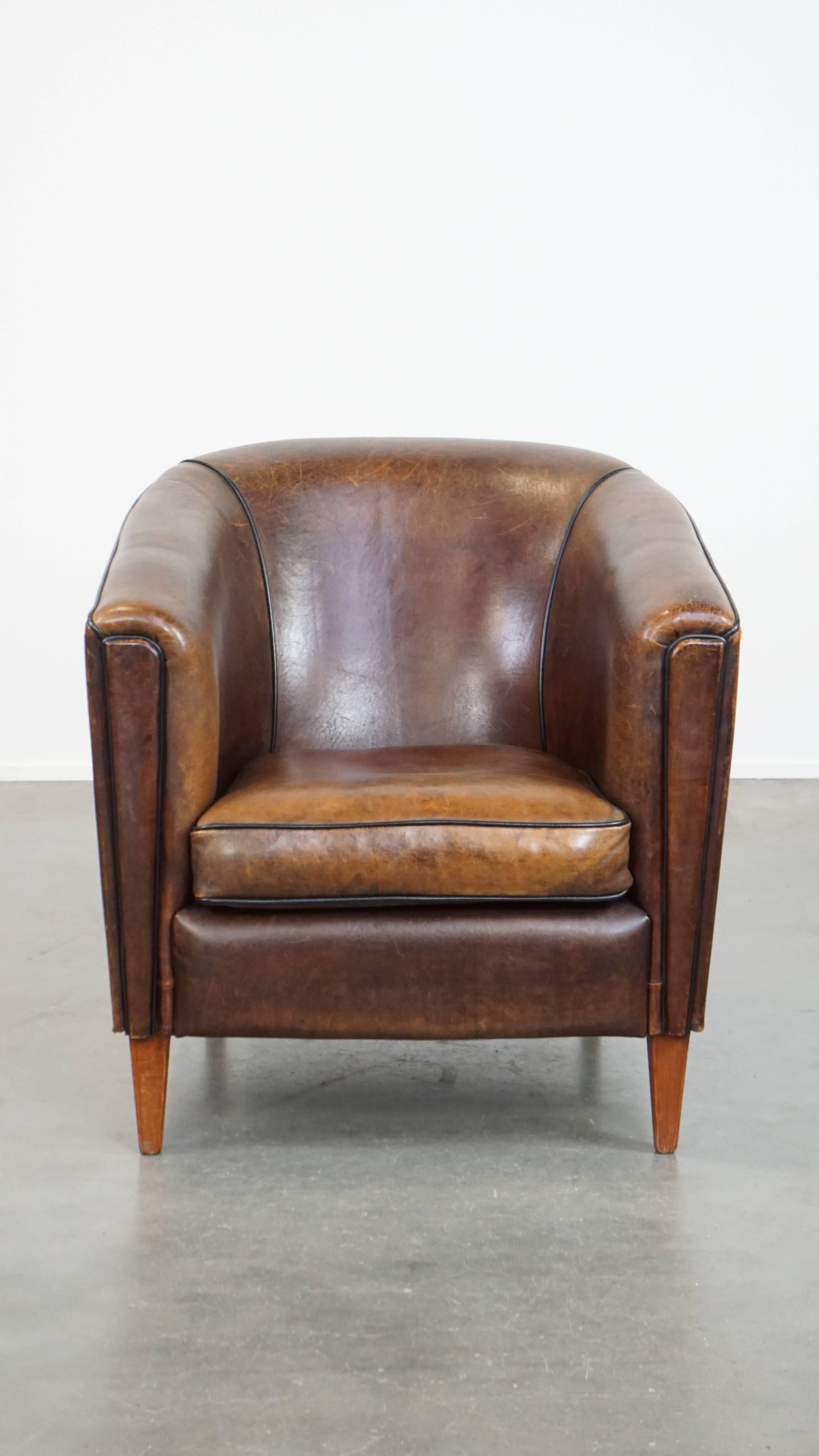 This dark sheepskin club armchair features beautiful colors and is a real eye-catcher that will feel at home in almost any interior. It has a sleek finish with black piping, exuding luxury and cleanliness. The club armchair comes with a removable