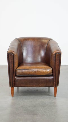Dark, sleek, luxurious sheepskin leather club armchair with beautiful colors