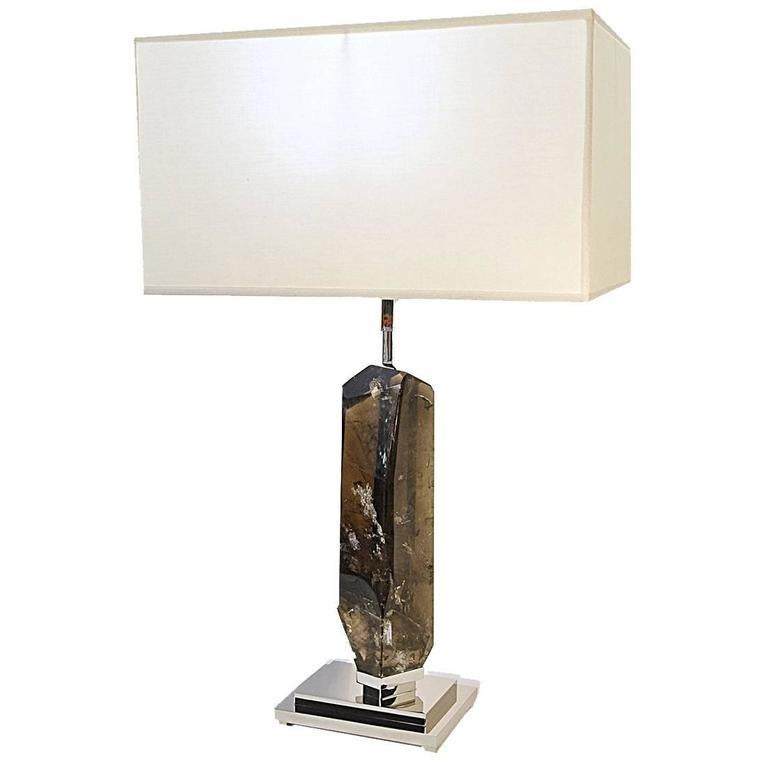 This unique and sophisticated lamp makes a bold statement in any home with its striking one-of-a-kind body crafted in hand-cut dark smokey quartz sourced in Madagascar and featuring countless inclusions, which add a freshness to the piece
