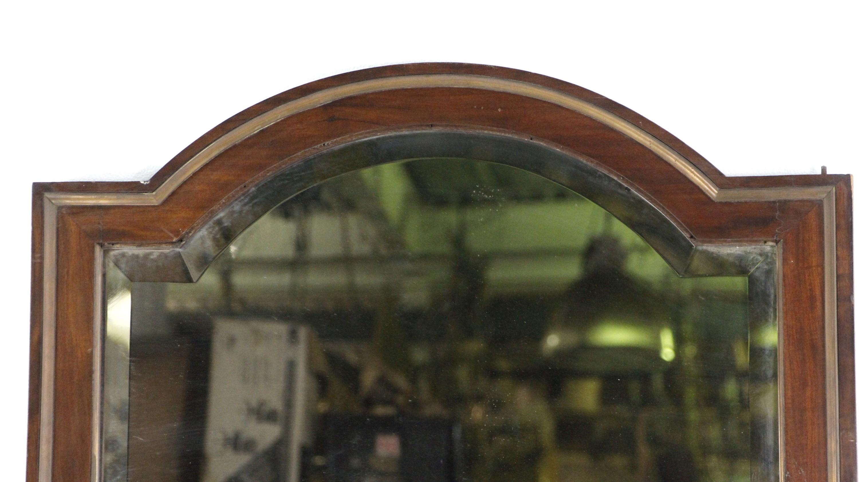 Early 20th century large size armoire door mirror. With a dark stain and brass trim edging. Features a slightly distressed beveled glass mirror. Comes with original key. Door frames has various chips and mars due to it's age. Please see images for