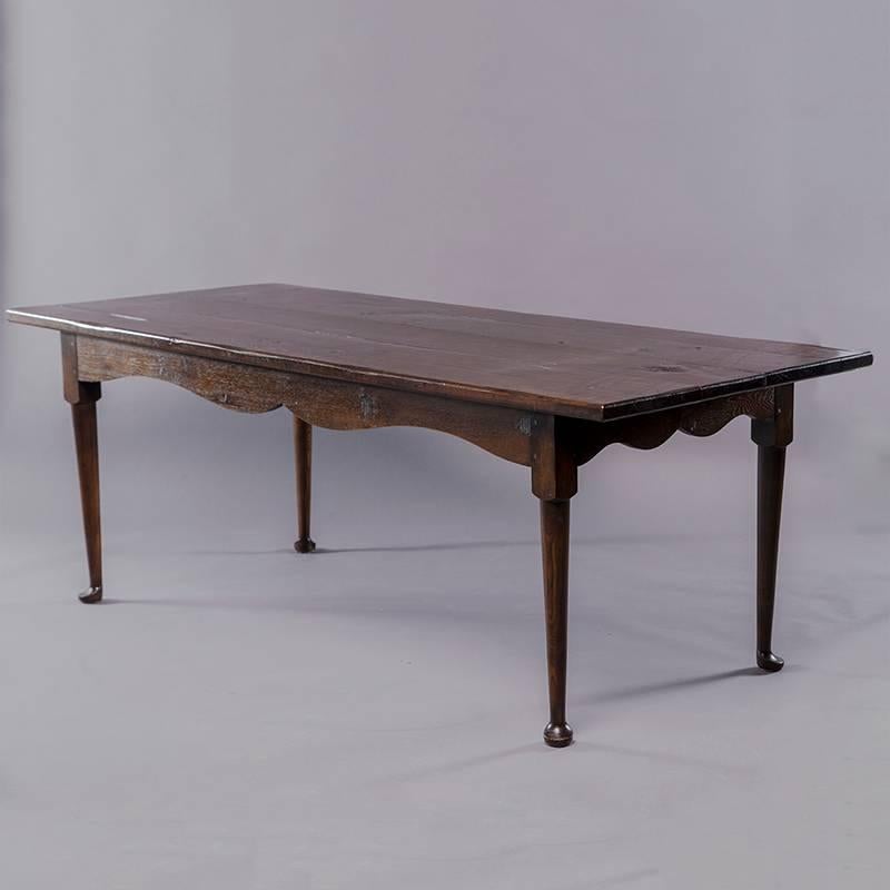 Circa 1960s dark stained pine dining table features traditional farm styling with wide planks, visible knots, scalloped apron and padded feet. Excellent vintage condition.