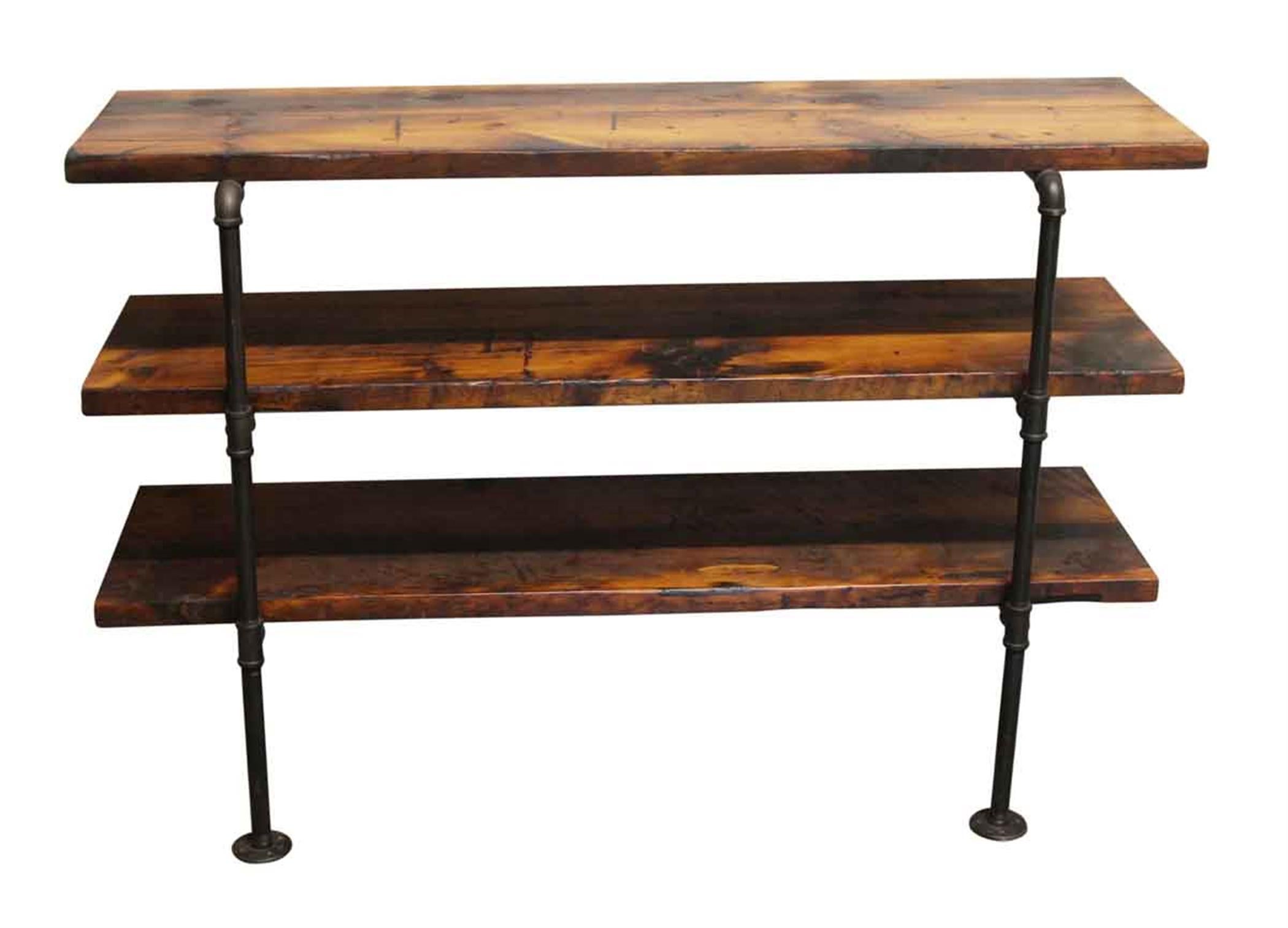 Dark wood tone three section pine wall mount shelf unit with black pipe legs. Must be mounted to a surface at the top and bottom. This can be seen at our 400 Gilligan St location in Scranton, PA.