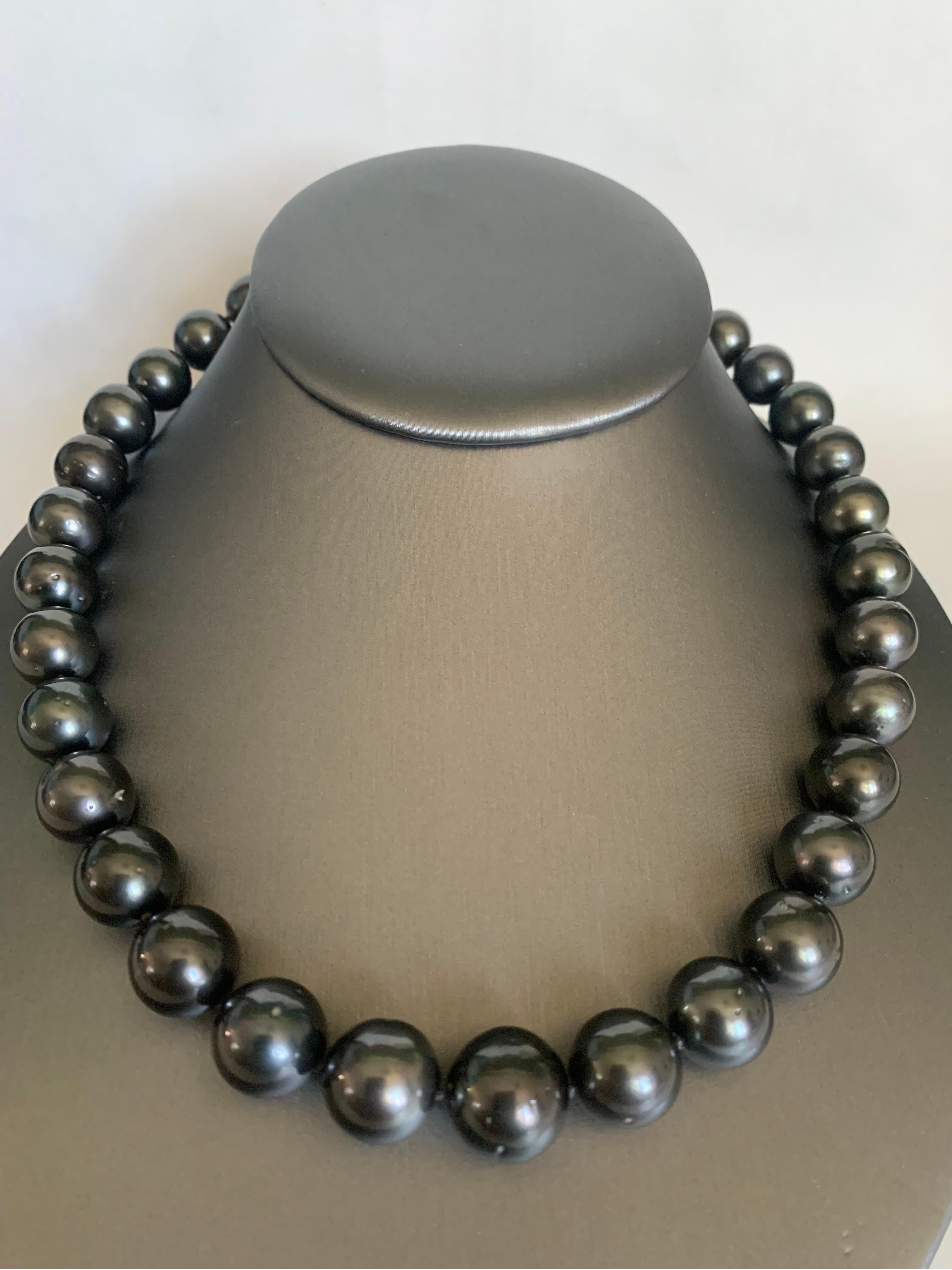 Elevate your look with a timeless graduated pearl necklace. This 18-18.5 inches length strand necklace is fully knotted and hand strung with matching silk cord. The necklace comprises 33 vivid sheen dark Tahitian pearls measuring 12-14.8 mm and