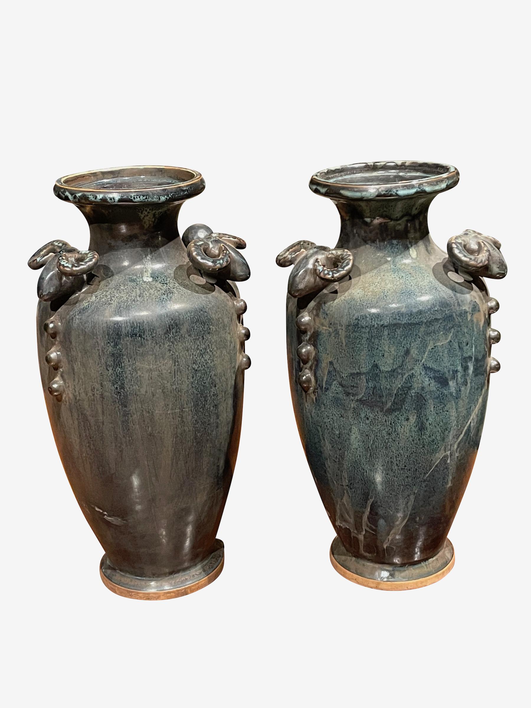 Vase contemporain chinois émaillé de turquoise foncé et de bronze.
Têtes de béliers décoratives à l'ouverture.
Deux disponibles et vendus individuellement.
