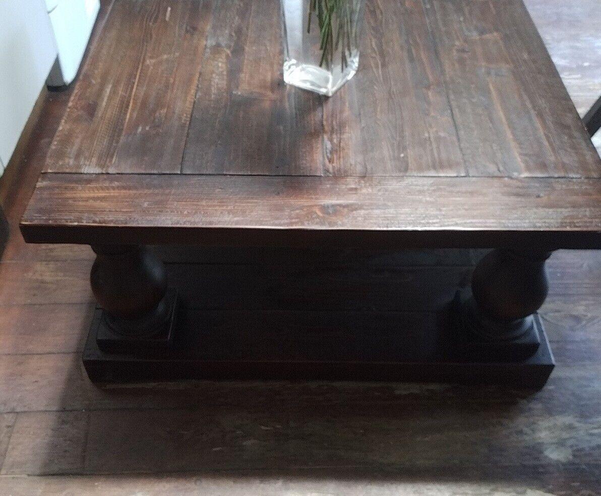 Bringen Sie einen Hauch von Eleganz in Ihr Wohnzimmer mit diesem schönen Couchtisch. Der Tisch ist mit einer Balustrade aus dunklem Walnussholz und klobigen Beinen ausgestattet, die ihm einen industriellen und soliden Look verleihen. Die Tischplatte