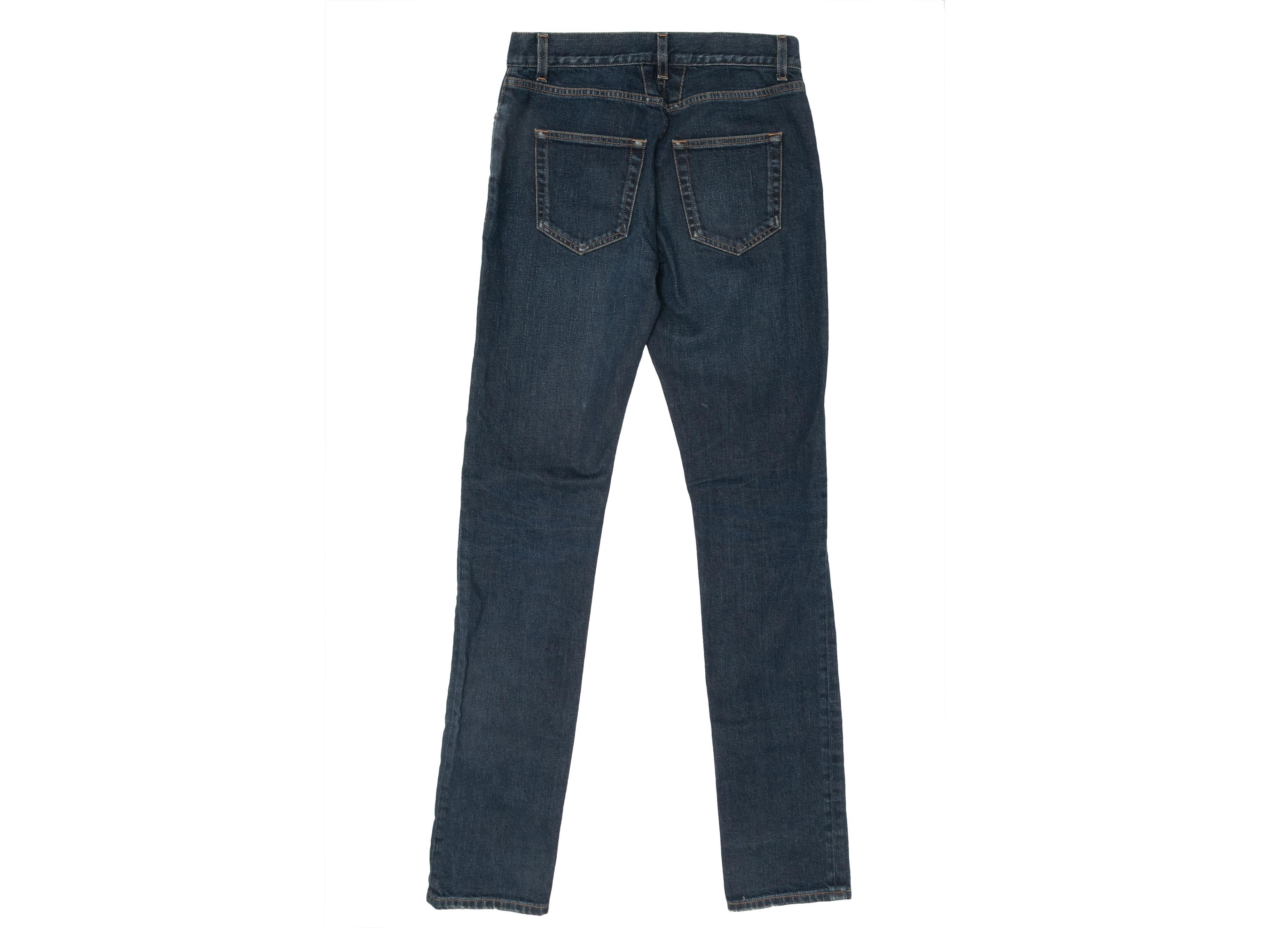 Product Details: Dark wash denim straight-leg jeans by Saint Laurent. Five pockets. Zip and button closures at front. 25