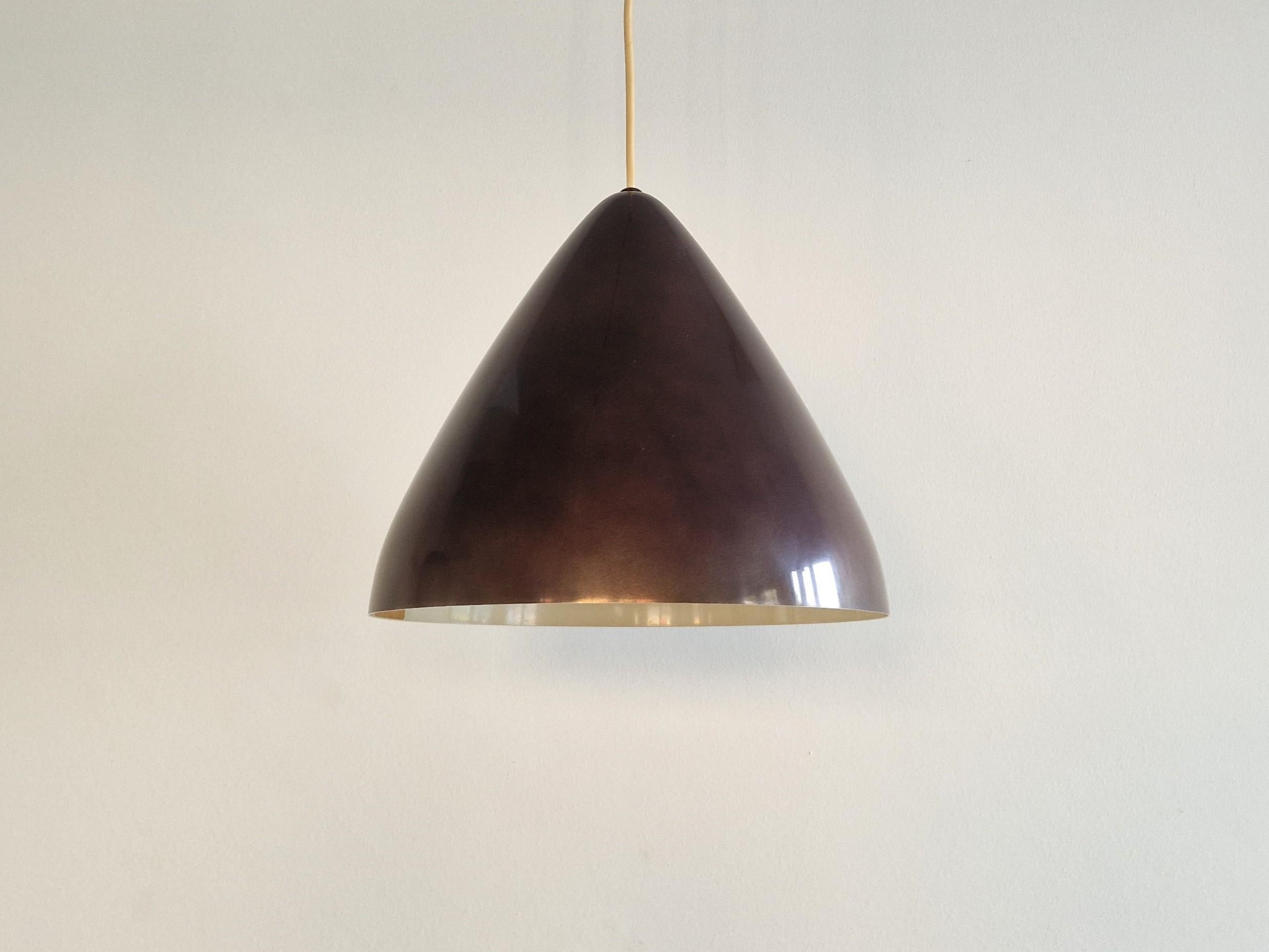 This iconic pendant light was designed by the Finnish designer Lisa Johansson-Pape for Orno. The lamp has a metalic dark wine red colored outside and a cream/off-white (due to age/use) inside. This lamp is labelled on the inside with the Orno label.