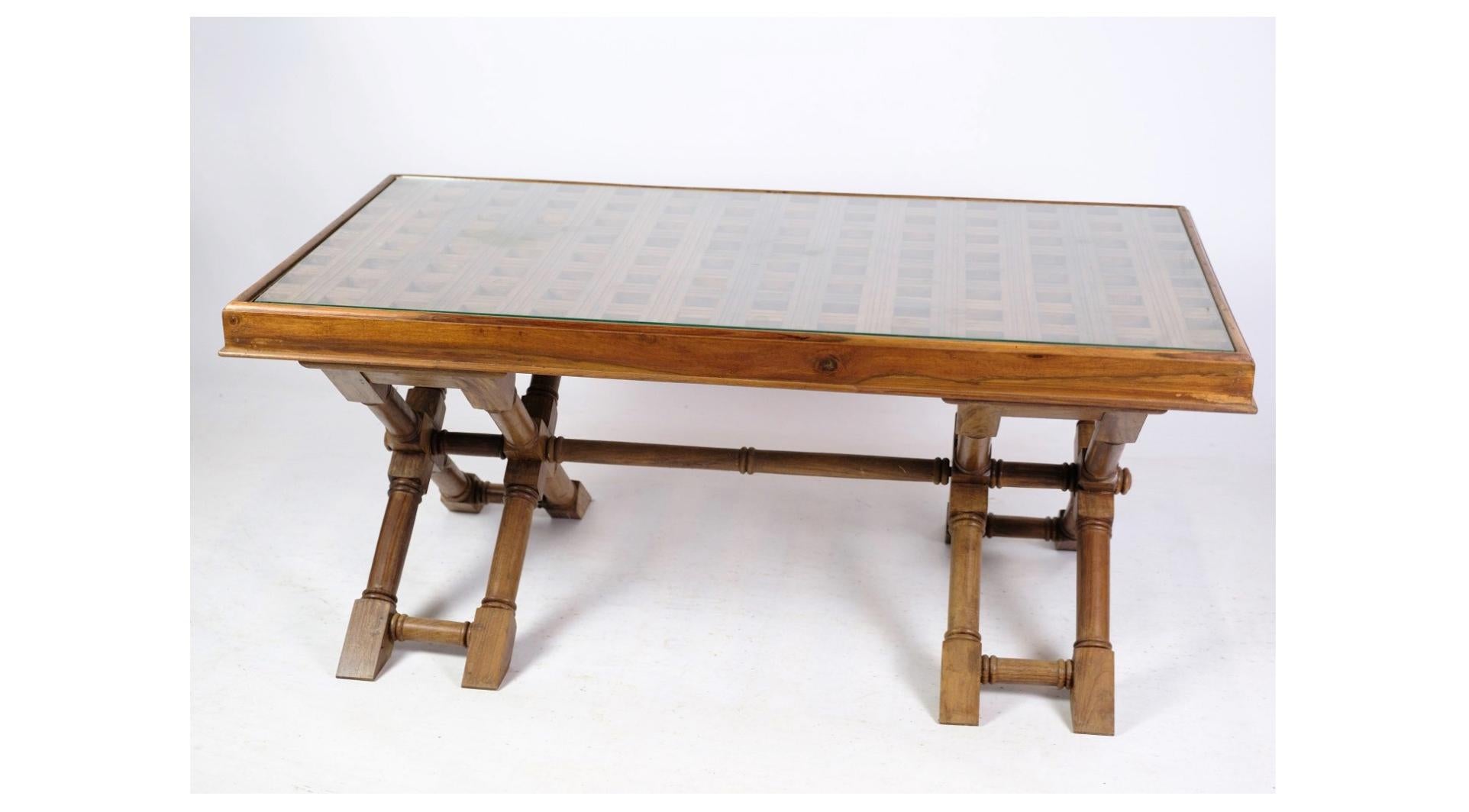 La table basse en bois foncé avec un plateau en verre datant des années 1960 est un classique du mobilier moderne du milieu du siècle qui dégage un style et une sophistication intemporels. Fabriquée en bois riche et sombre, cette table basse