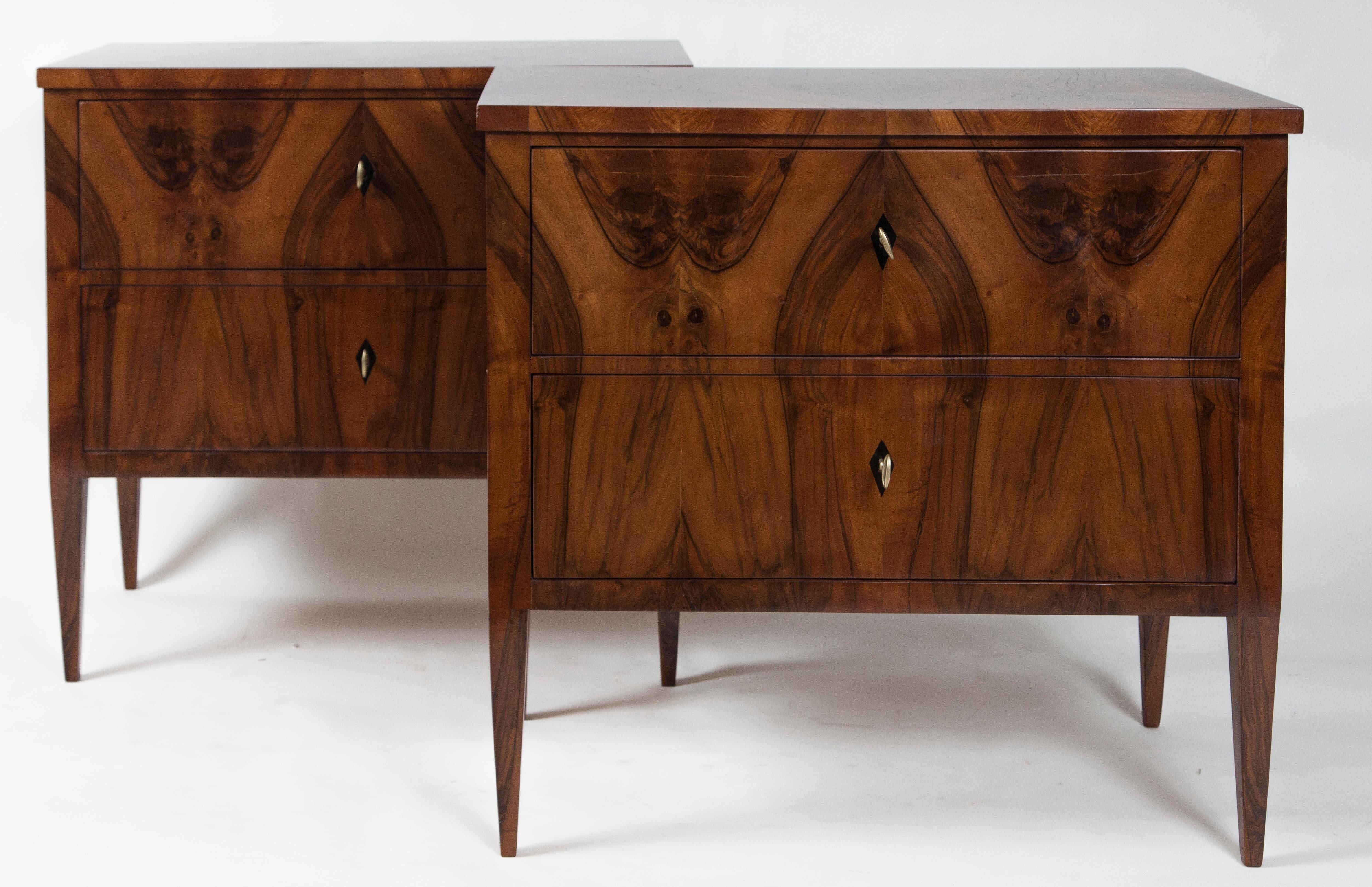 Darker pair of Biedermeier style chest of drawers in walnut veneer on pine, comprised each of two drawers adorned with diamond inlaid shaped keyholes and finishing on high tapered legs
Refurbished and restored with a wax polish, finish is more