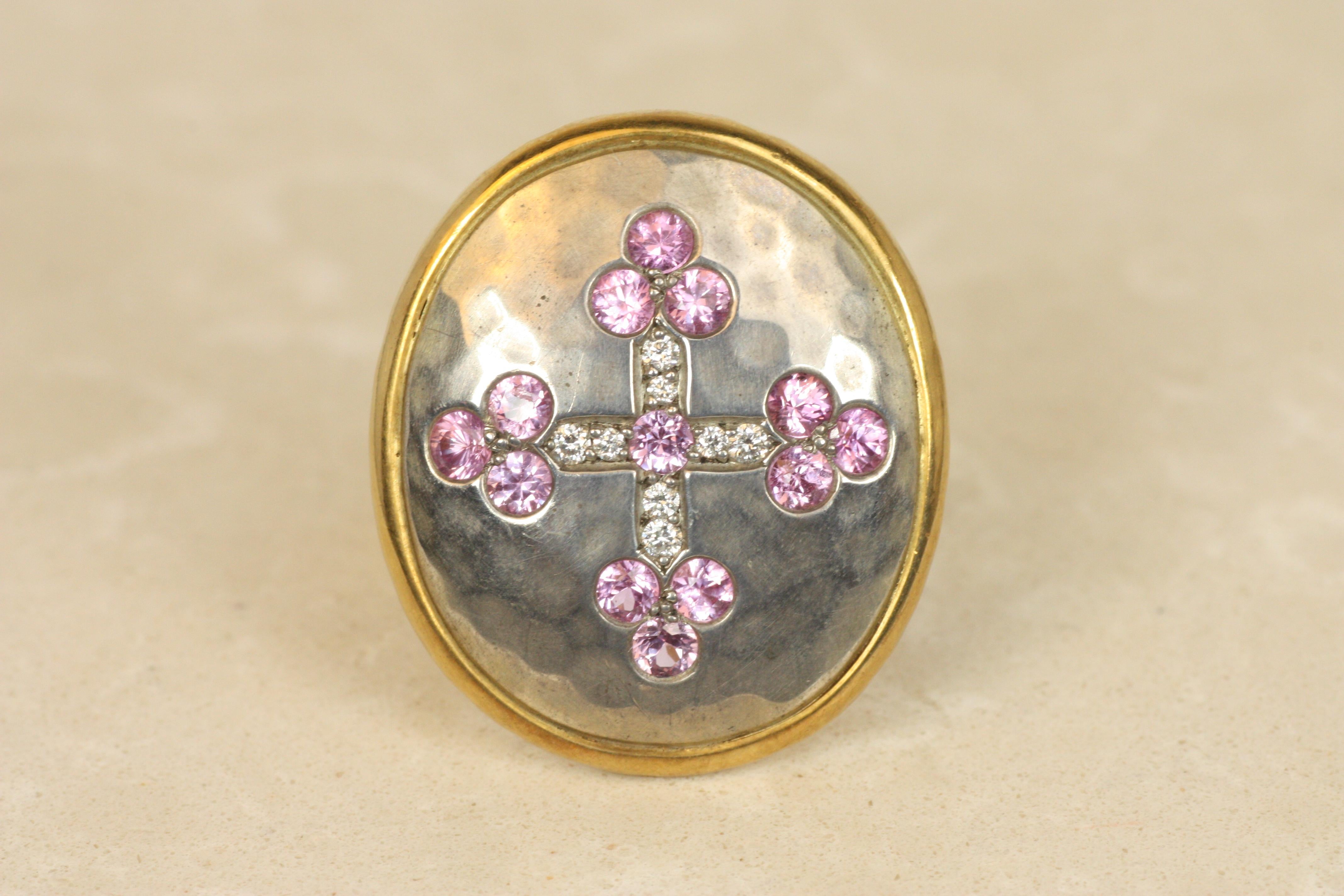 Echoing the grandeur of medieval craftsmanship, this regal shield ring by the renowned Darlene deSedle is adorned with a brilliant cross of diamonds and pink sapphires. The sterling silver 