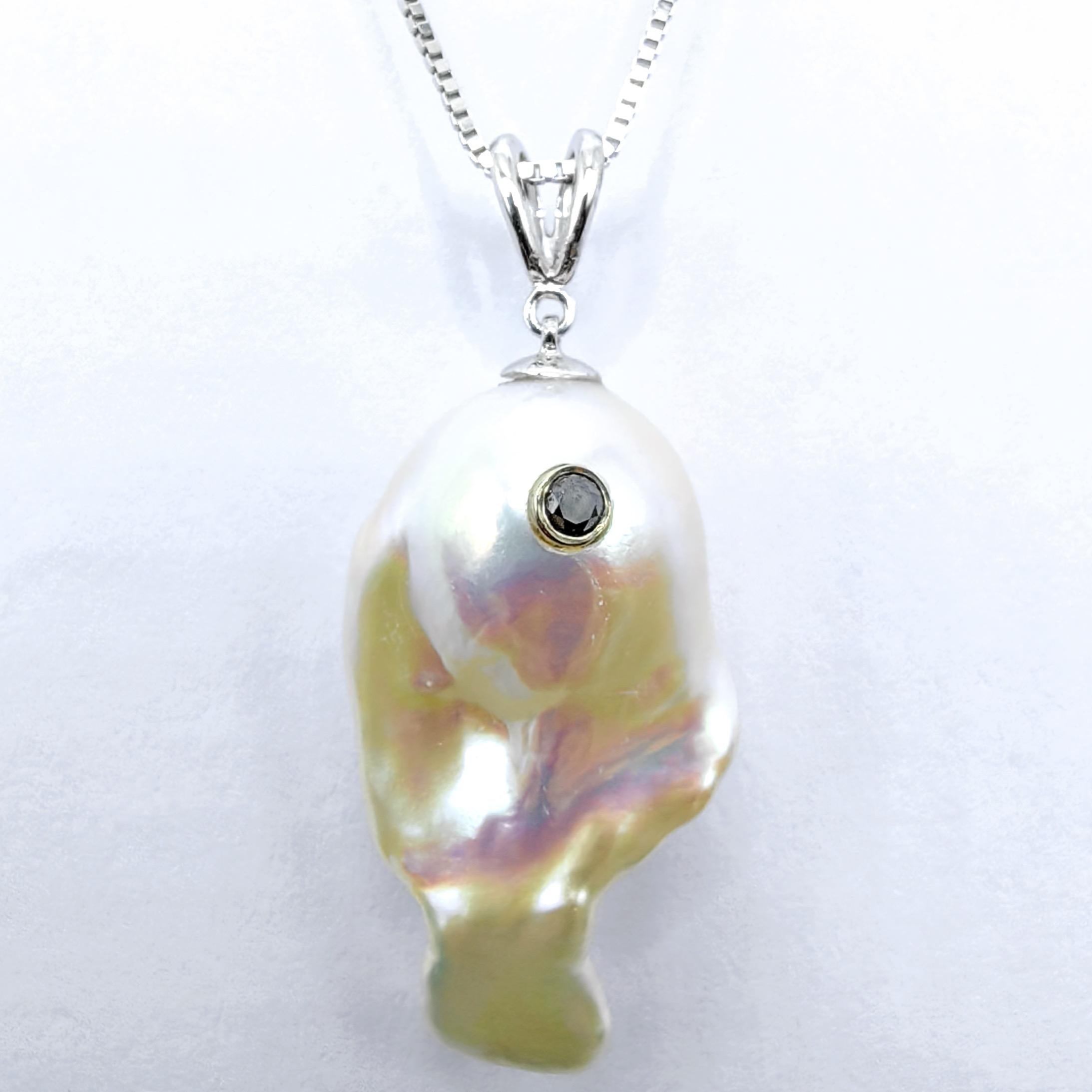 Cél�ébration de la grâce aquatique et de la beauté naturelle, cet extraordinaire pendentif poisson en or blanc 18 carats capture l'essence de l'élégance fluide à travers l'art de la joaillerie fine. En son cœur se trouve une magnifique perle de
