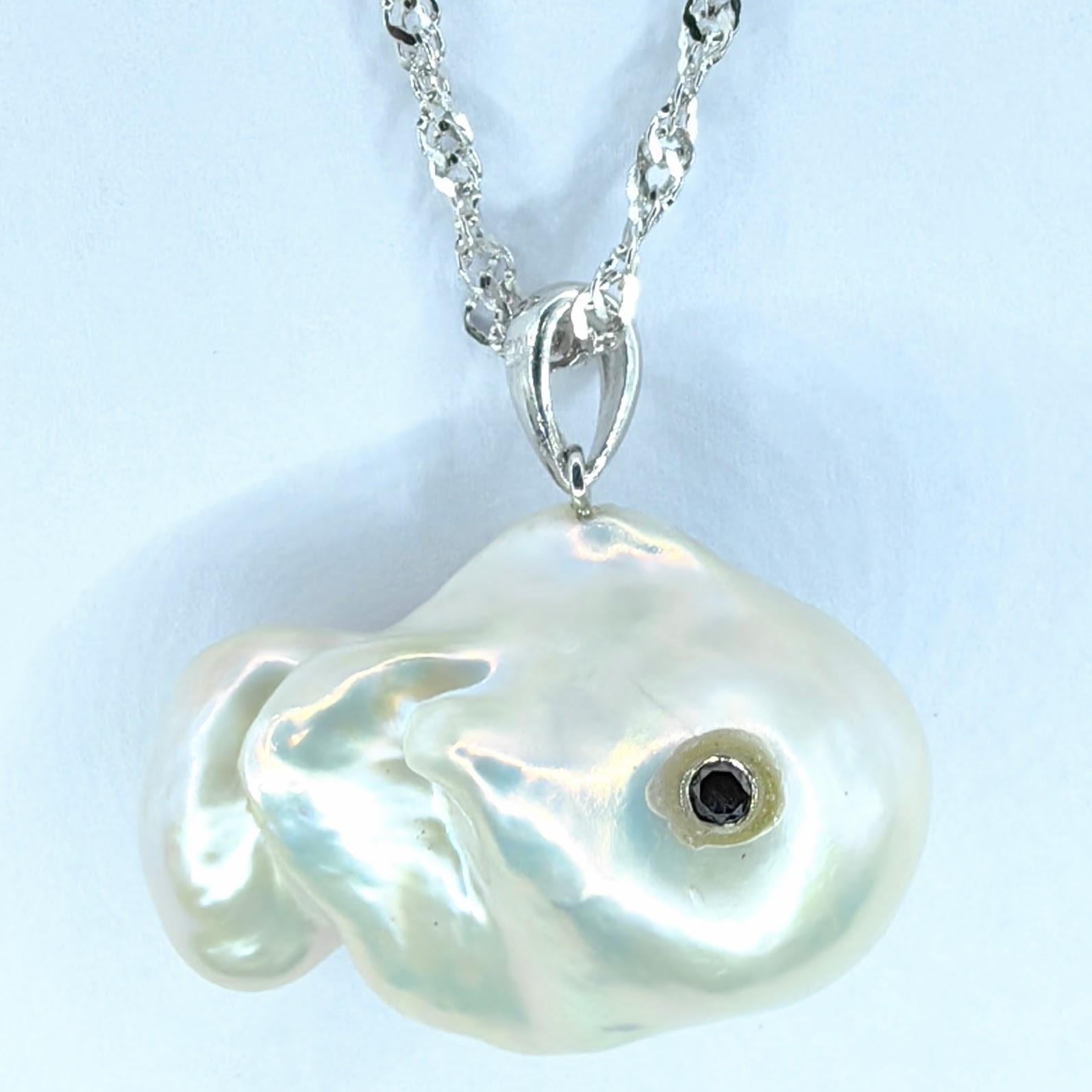 Plongez dans les profondeurs fantaisistes d'un charme inspiré de l'océan avec le captivant pendentif Darling Fish : Black Diamond Baroque Pearl en or blanc 18 carats. Fabriqué à partir d'une perle baroque d'eau douce lumineuse, ce pendentif ludique