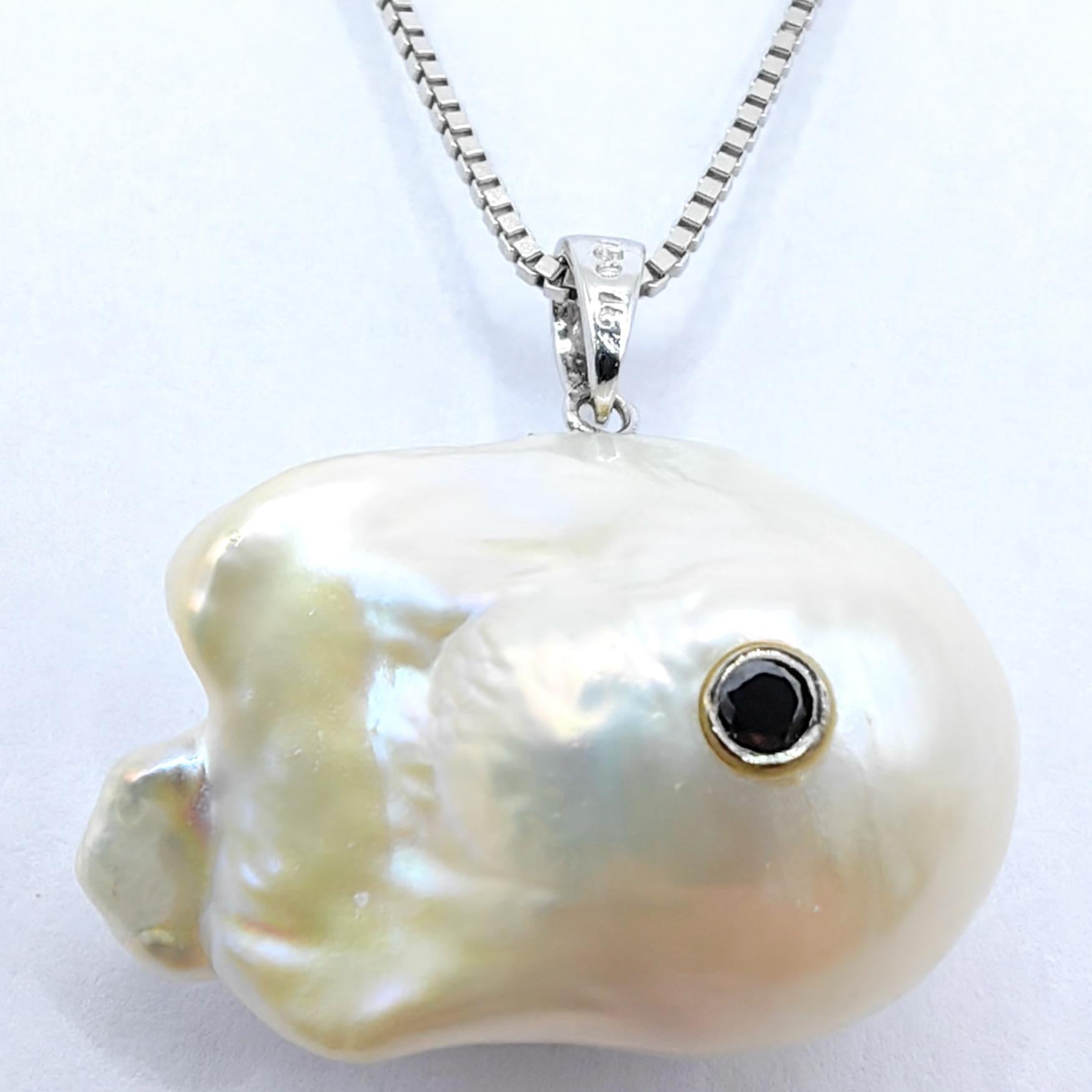 Plongez dans l'allure enchanteresse de l'élégance d'inspiration marine avec l'envoûtant pendentif Darling Fish : diamant noir et perle baroque en or blanc 18 carats. Façonnée à partir d'une perle baroque de culture d'eau douce d'un poids remarquable