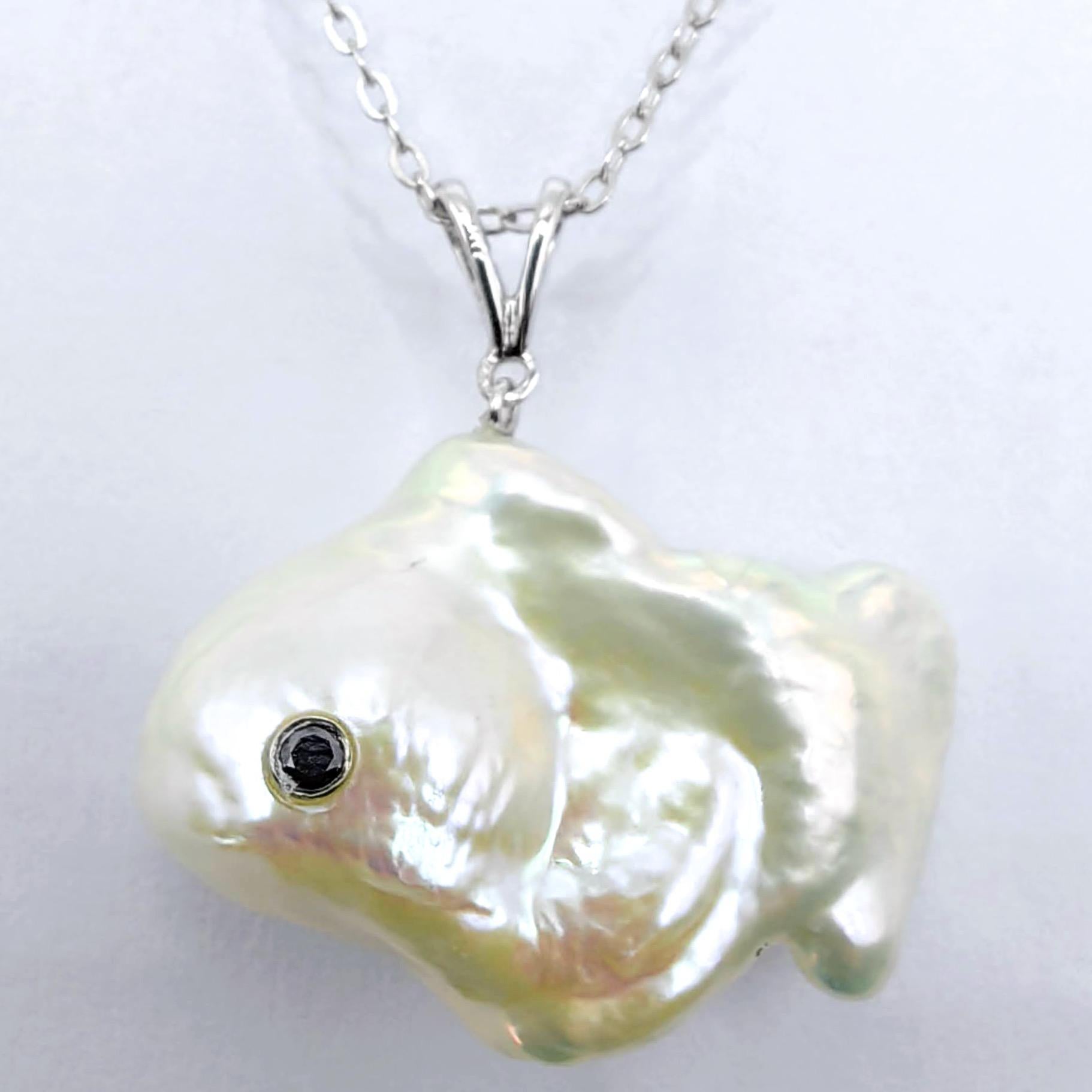 Discover the enchanting beauty of underwater elegance with the captivating Darling Fish: Black Diamond Baroque Pearl Pendant in 18K White Gold. Crafted from a magnificent freshwater cultured baroque pearl weighing an extraordinary 29.87 carats, this