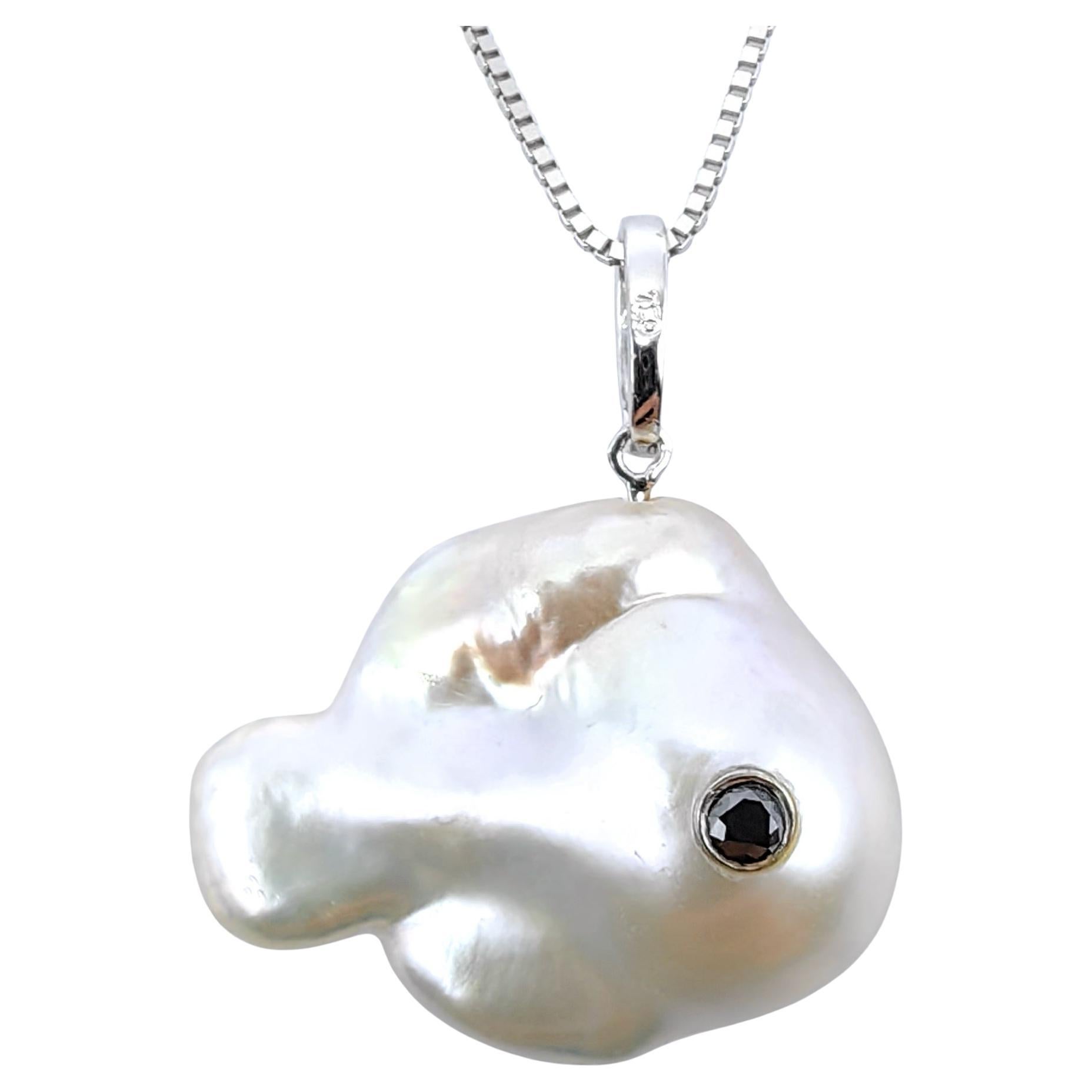 Capolavoro di stravagante raffinatezza, questo straordinario pendente a forma di pesce in oro bianco 18 carati trasforma l'ispirazione acquatica in lusso contemporaneo. Il suo cuore è costituito da una magnifica perla d'acqua dolce coltivata barocca