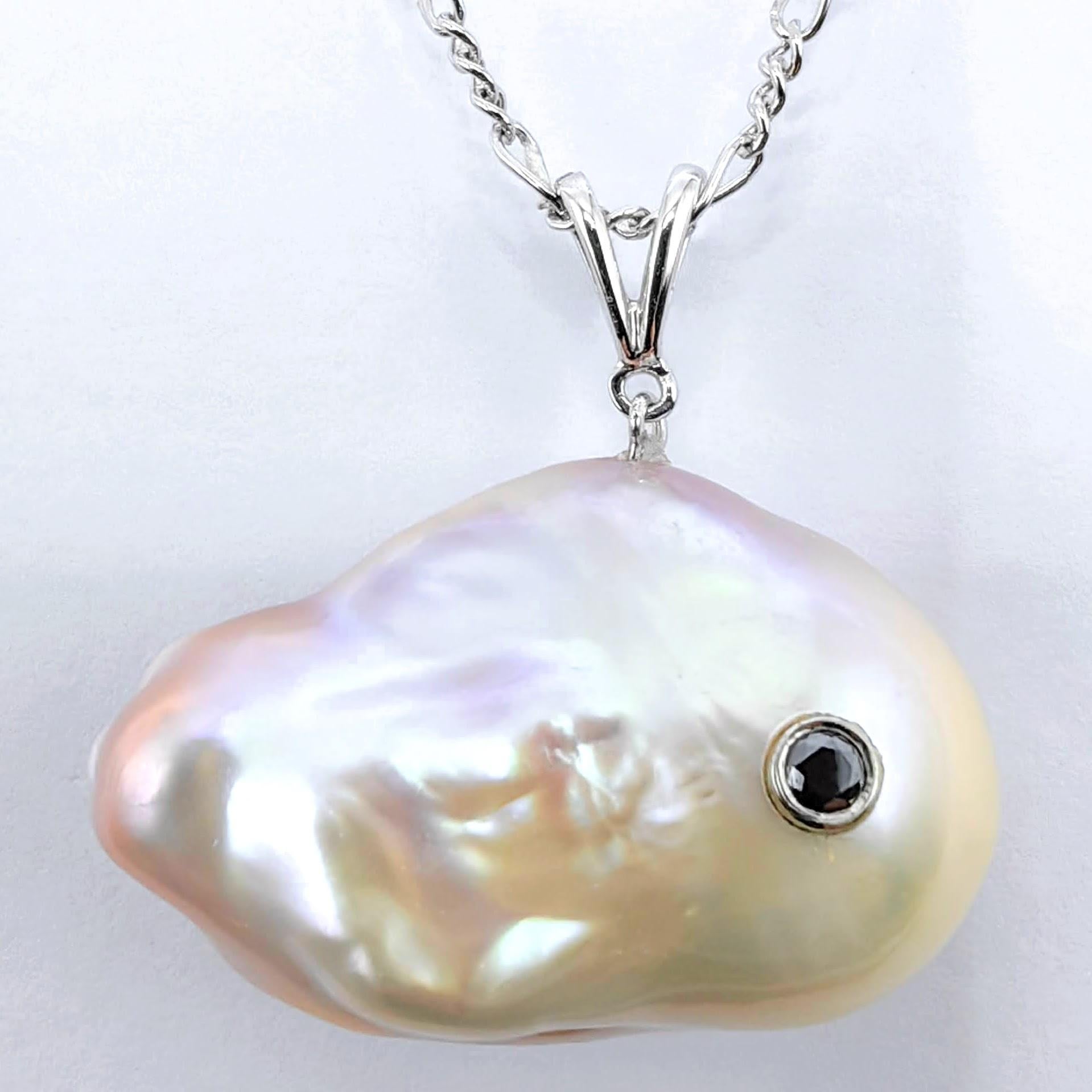 Discover the enchanting allure of the ocean's most treasured creation with the captivating Darling Fish: Black Diamond Pink Champaign Baroque Pearl Pendant in 18K White Gold. This charming piece features a magnificent freshwater cultured baroque