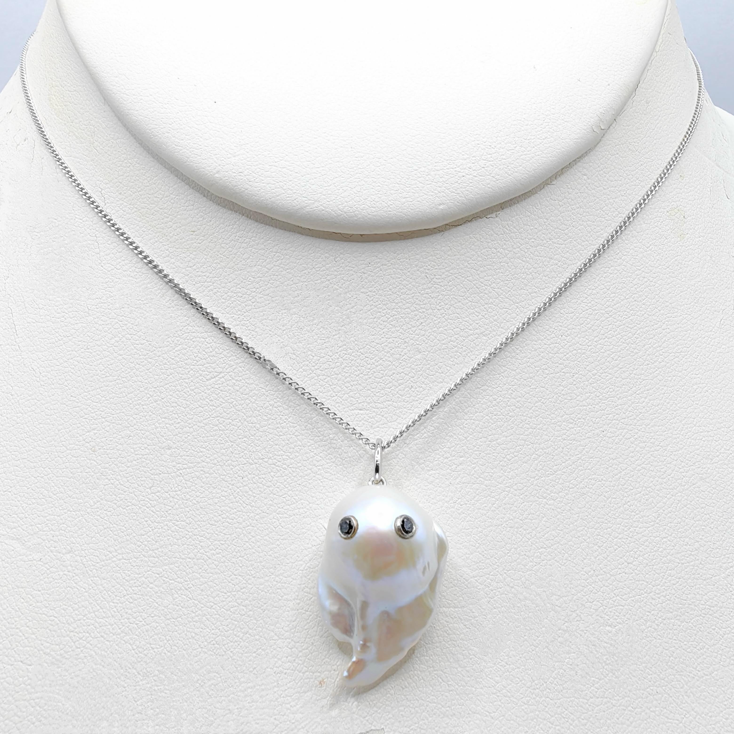 Unveil the enchanting Darling Phantom: a whimsical marvel featuring a Black Diamond accented Baroque Pearl set in 18K White Gold, evoking the spirit of a friendly ghost. This adorable piece, with a pendant length of approximately 1.10 inches, is