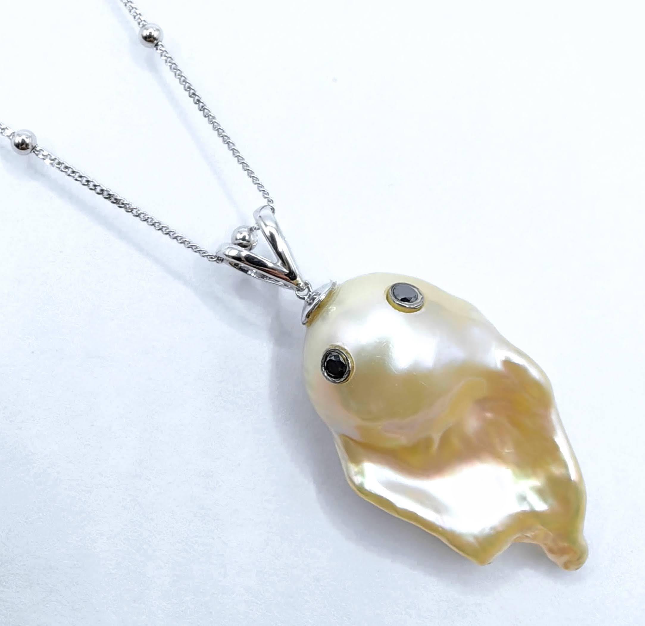 Enthüllen Sie das bezaubernde Darling Phantom XL - ein extragroßer, skurriler Charm, der die geheimnisvolle Anziehungskraft schwarzer Diamanten und den ätherischen Glanz einer natürlichen champagnerfarbenen Barockperle in glänzendem 18-karätigem