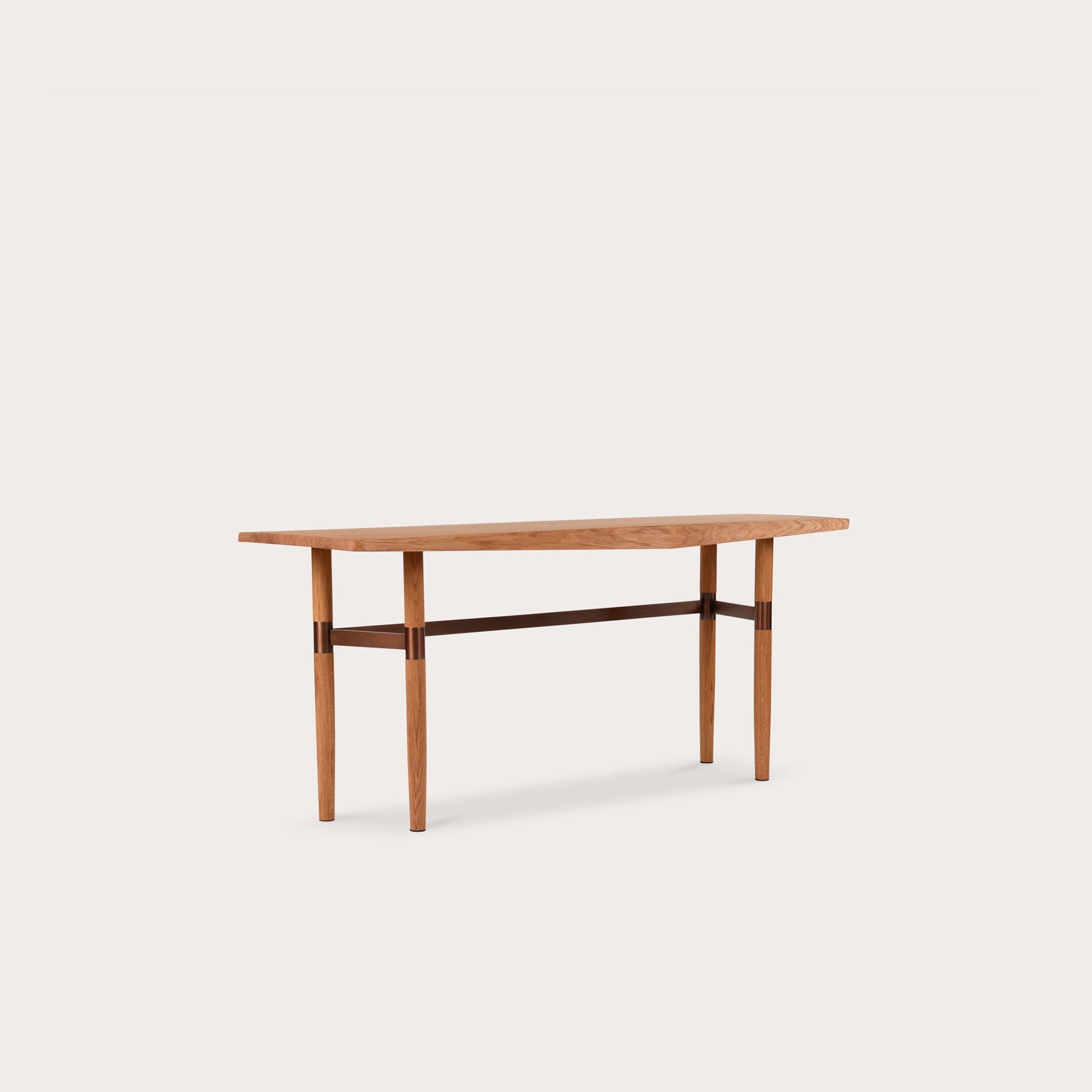 This Darling Point Console by Yabu Pushelberg in whiskey ultra matte lacquered oak is paired with a golden or bronze coloured brass finish frame.

Yabu Pushelberg’s design for the darling point console is hand-hone by craftsmen from sustainably