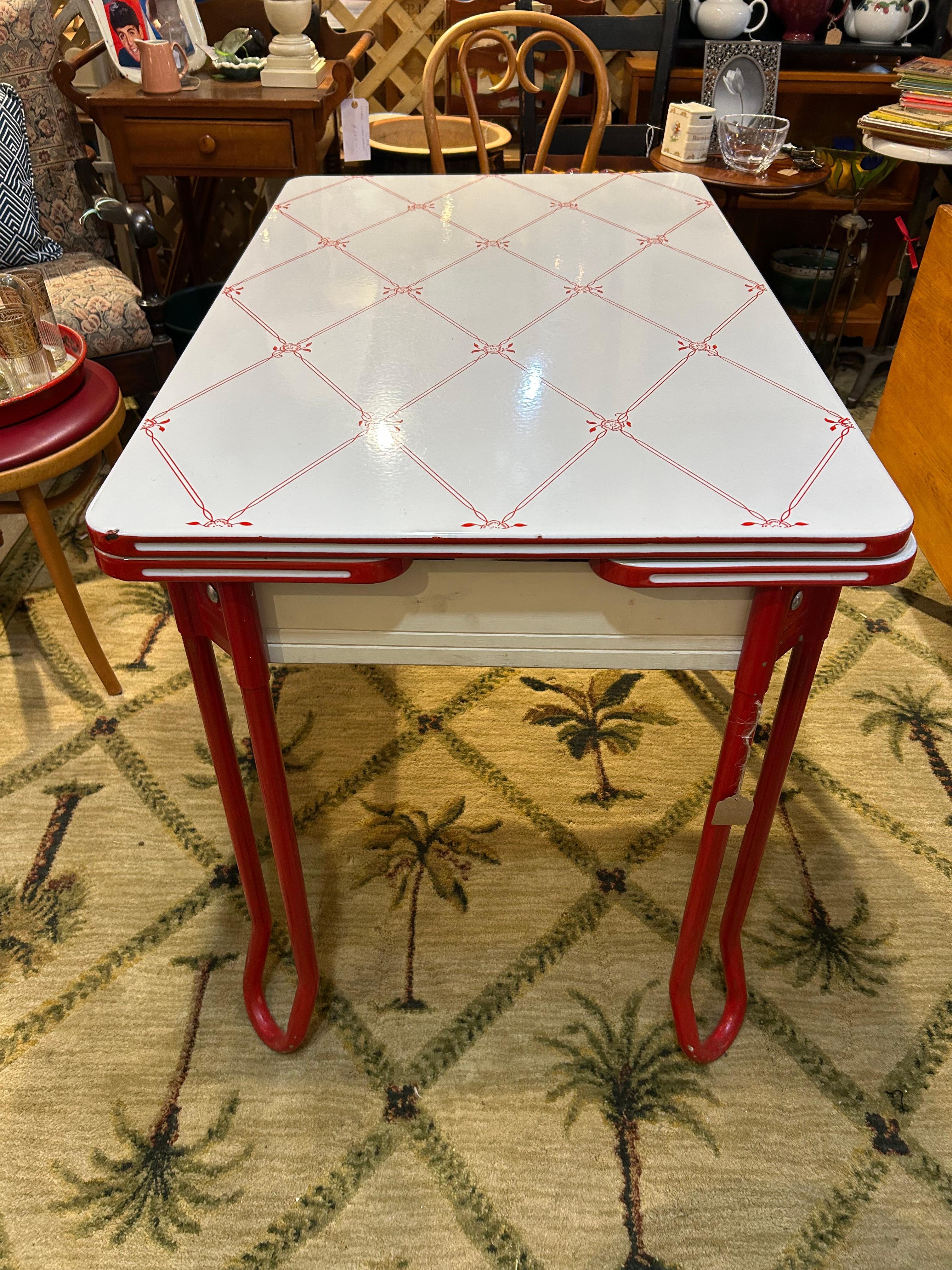Adorable retro red and white enamel breakfast table with single drawer.  Closed dimensions are above.  Each side pulls out so table can extend to 44.75 w 
Apron 24