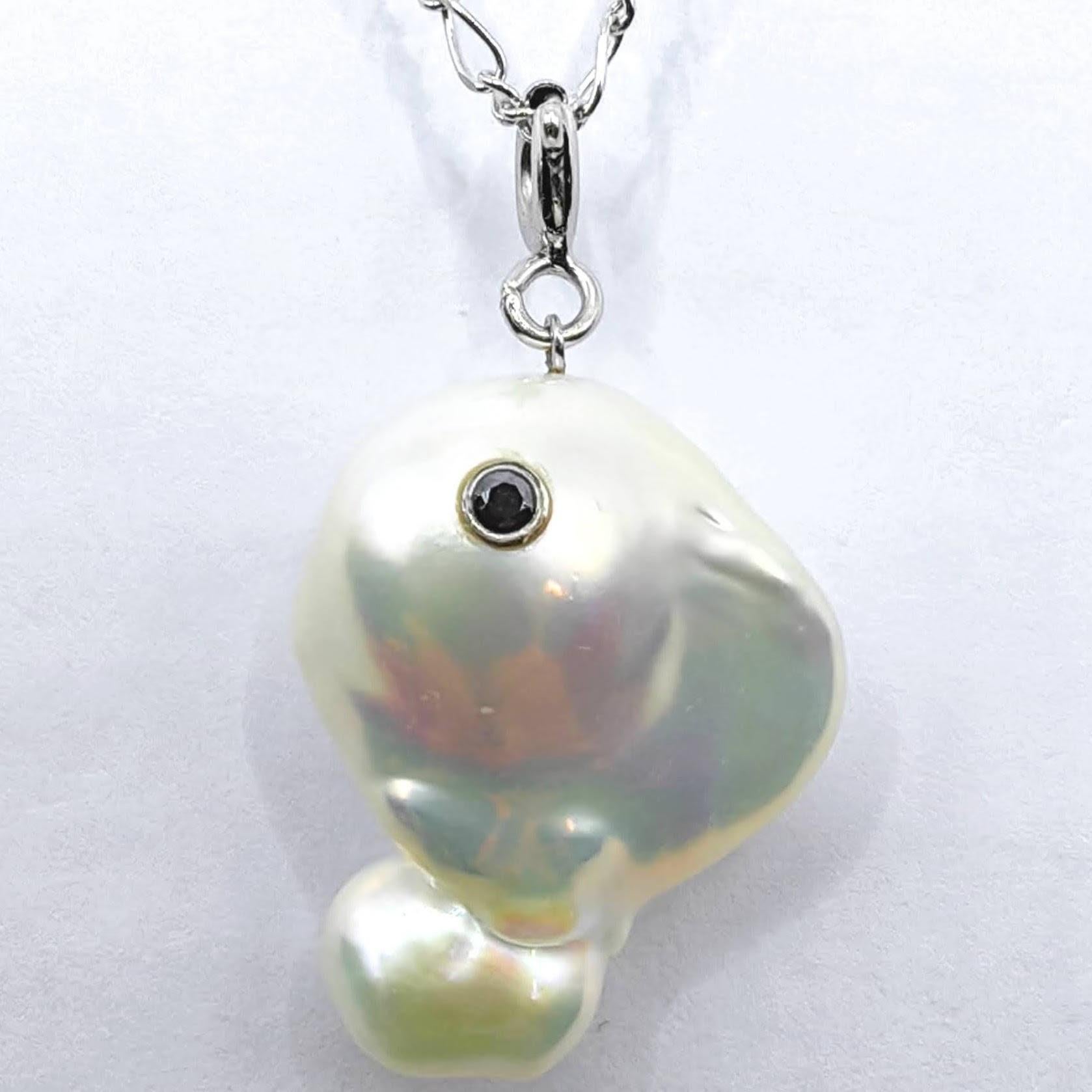 Rencontrez le plus charmant des vagabonds arctiques avec l'envoûtante baleine Darling : Pendentif Beluga en or blanc 18 carats avec perles baroques et diamants noirs. Cette pièce captivante transforme une magnifique perle baroque de culture d'eau