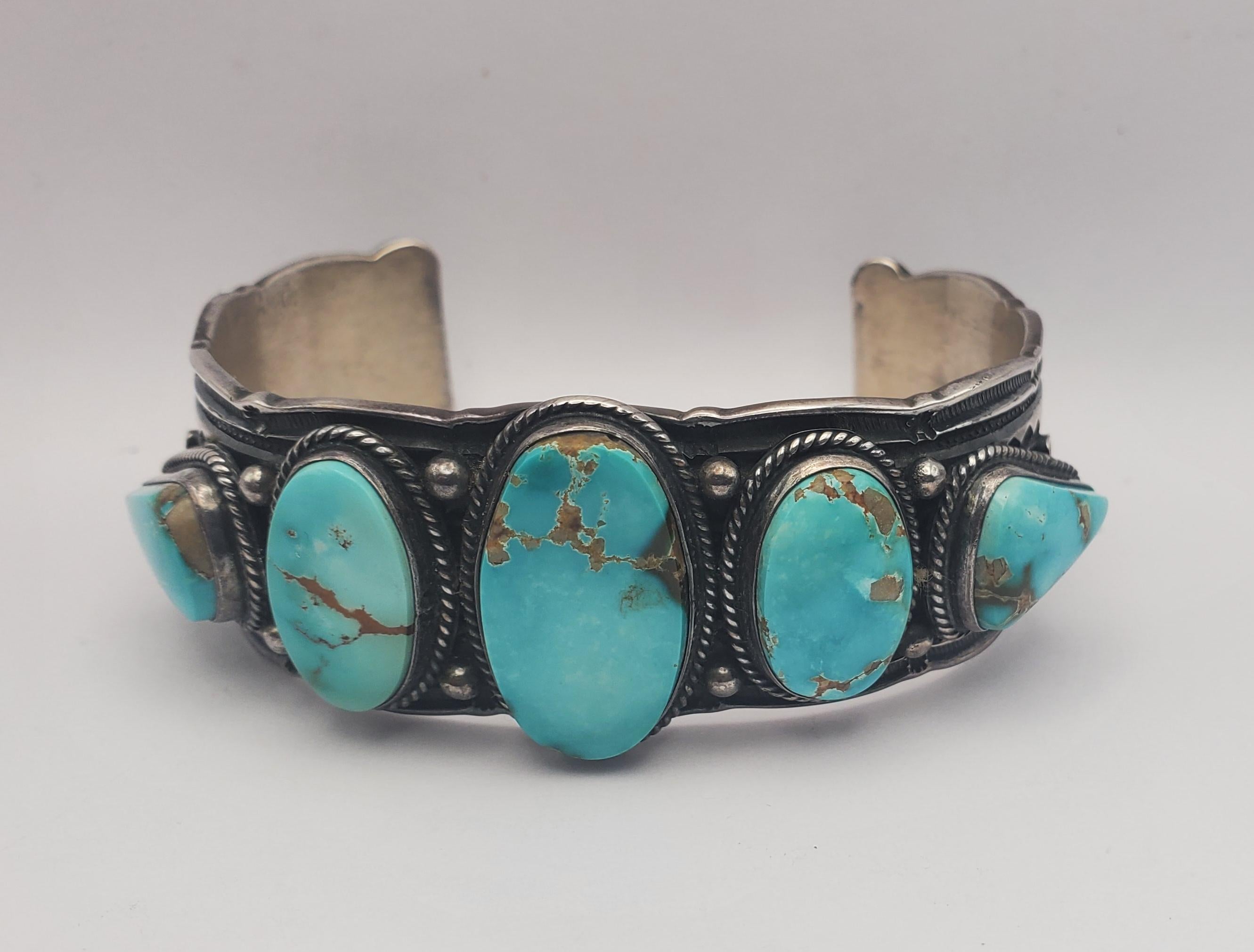 Absolutely stunning heavy stamped sterling silver and Royston turquoise cuff bracelet by master Navajo silversmith Darrell Cadman. This cuff features an abundance of hand-applied stamp work with 3 oval and two pear shaped bezel set blue Royston