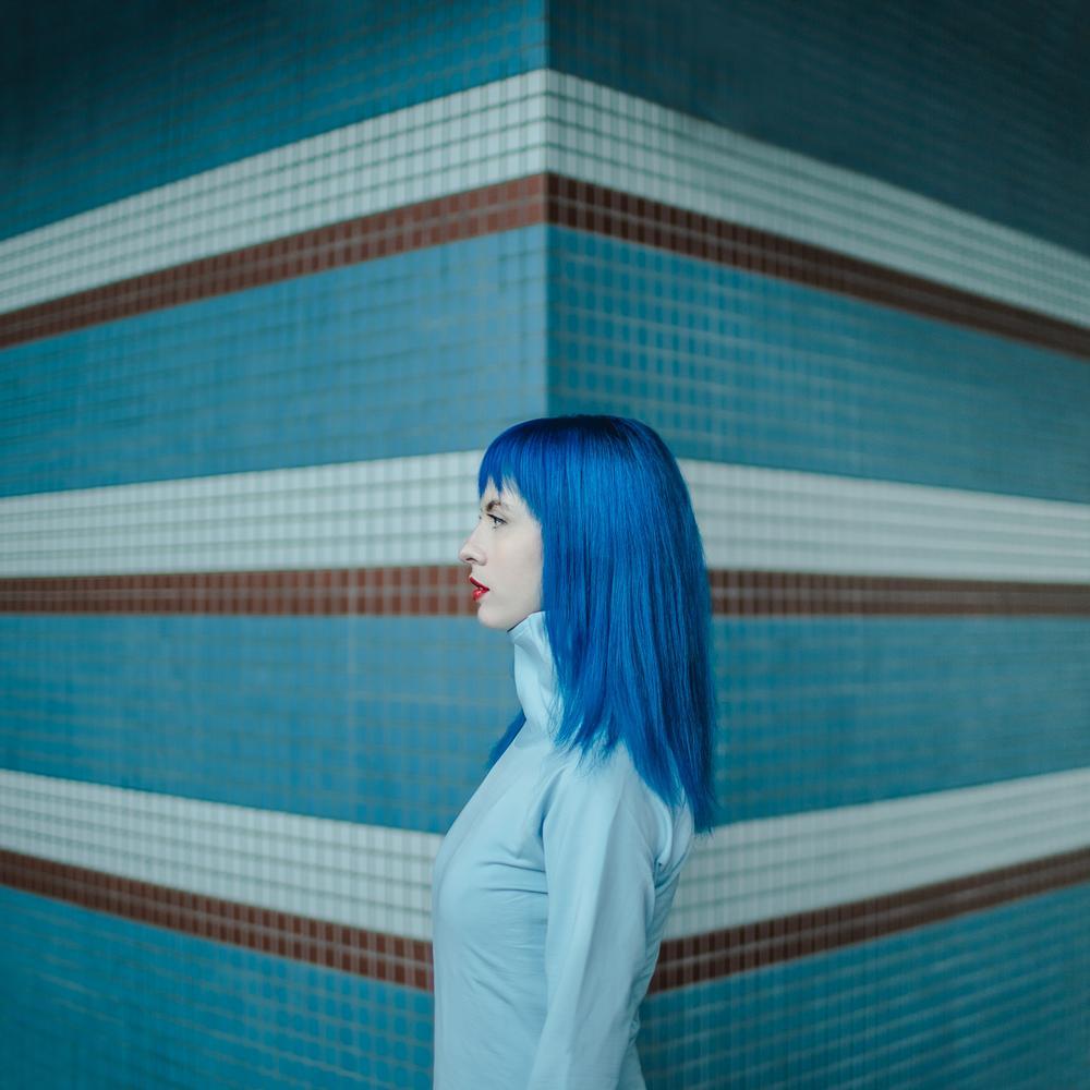 Vibrant blues of a Helsinki train station match the vibrant blue hair of the woman in the photo. Horizontal color tile stripes accentuate the feeling of abstraction and geometry. This is a limited edition color photograph. Number 1 of 4 is currently