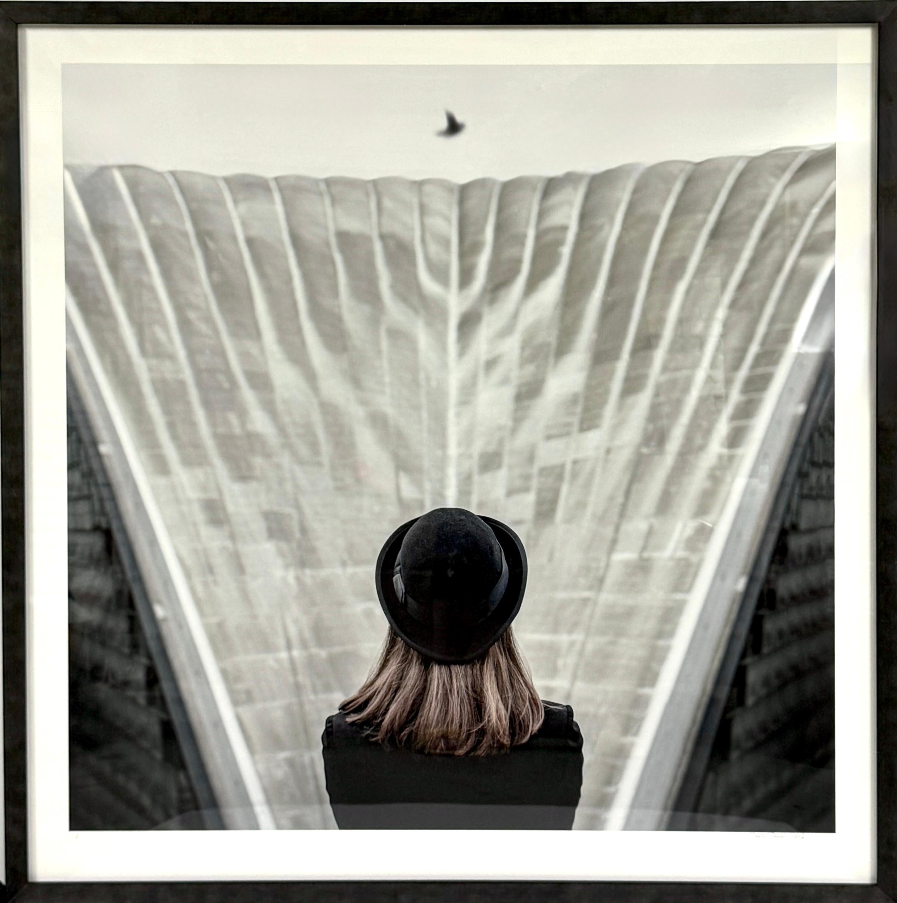Photographie couleur encadrée d'une femme avec un chapeau noir de style Magritte, architecture grise en vente 3
