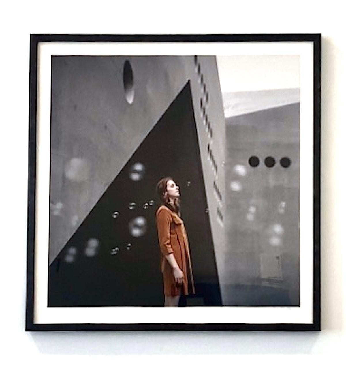 Photographie couleur encadrée avec femme, bulles, architecture géométrique grise, orange - Gris Color Photograph par Dasha Pears