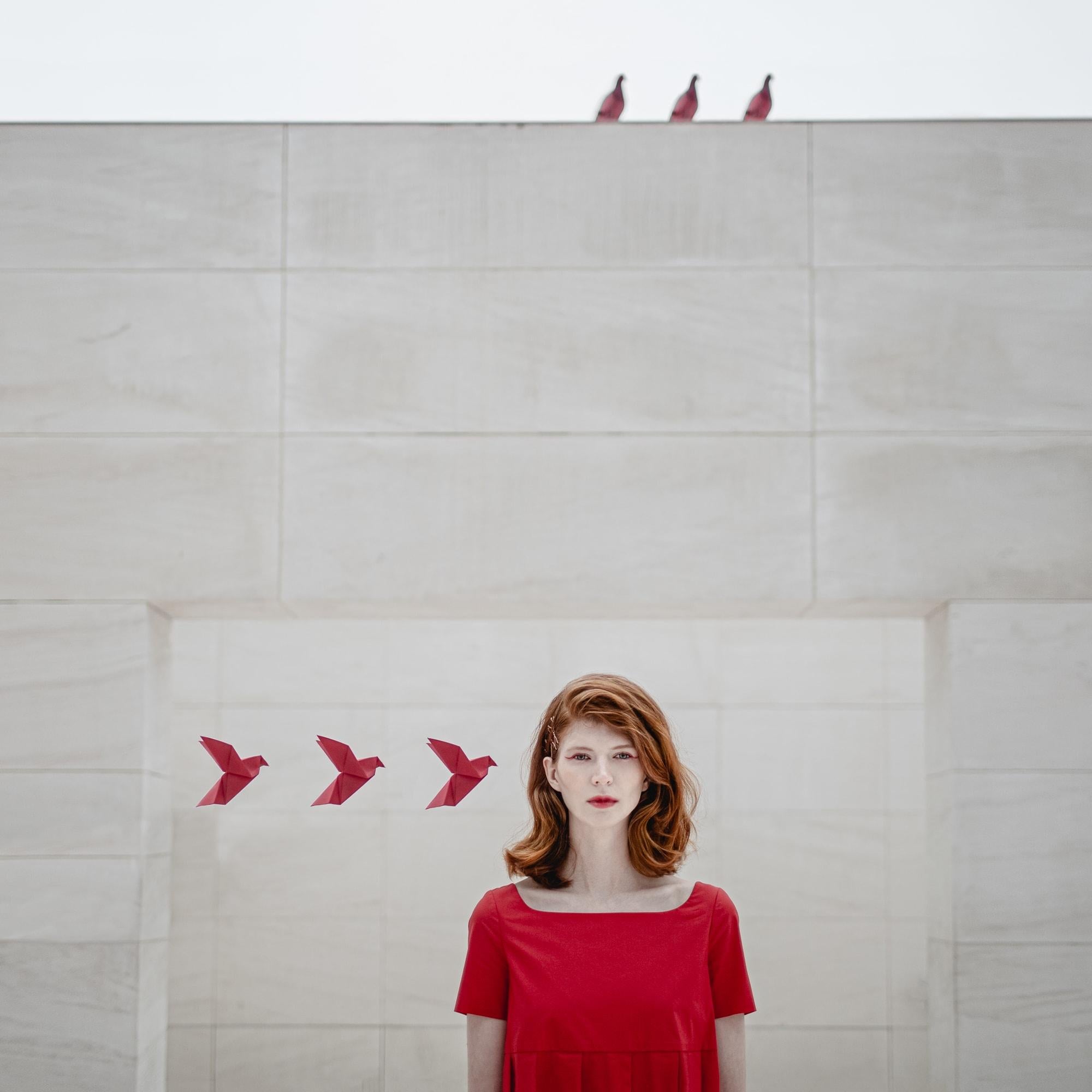 This beautifully vibrant red surreal portrait was shot in Barcelona. Dasha Pears cleverly combines origami birds with real birds to create a balanced minimalist composition. This is a limited edition color photograph. Number 1 of 8 is currently