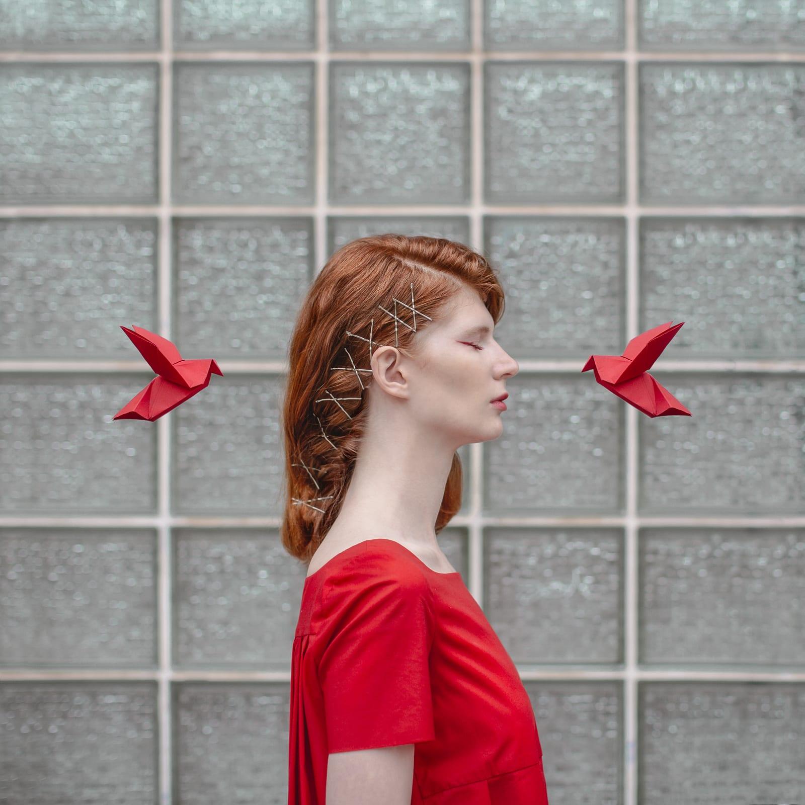 This beautifully vibrant red surreal portrait was shot in Barcelona. Dasha Pears uses origami birds to create a dialogue between the subject and her emotions. This is a limited edition color photograph. Number 1 of 5 is currently available, framed