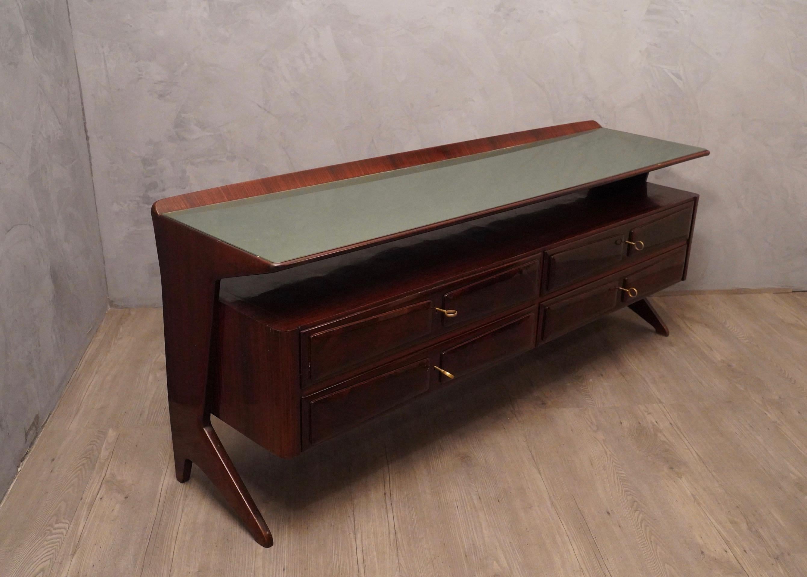 Very very special for its design of this Vittorio e Plinio Dassi's chest of drawers, from the middle of the century. 

All veneered in walnut, with green lacquered glass top. Commode that differentiates for a body with four drawers, and two side