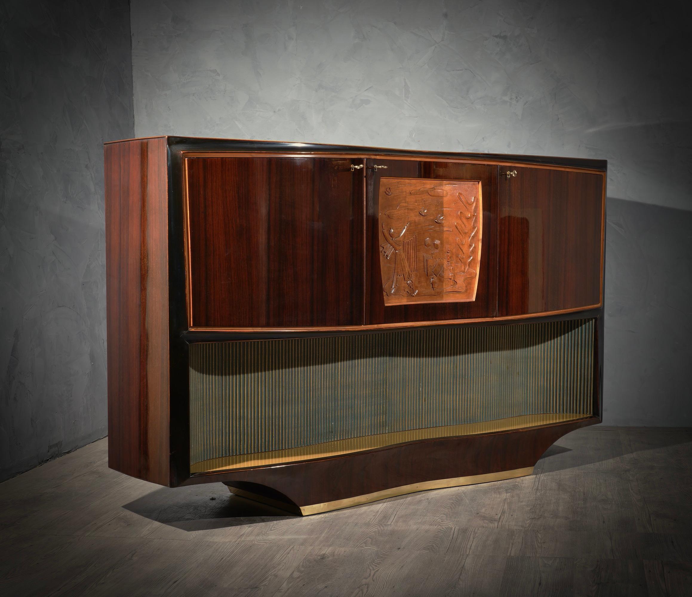 Bar cabinet buffet by Vittorio Dassi, composed of precious materials, such as walnut wood, brass and glass.

All veneered in walnut wood. Top in gold colored glass, recessed. Three front doors, which follow the movement of the top. The two sides are