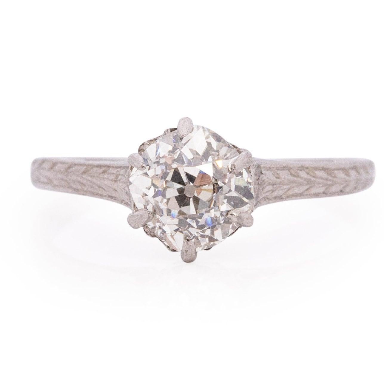 Presenting a gracefully understated Edwardian solitaire engagement ring. The centerpiece features an old European cut diamond cradled in a cathedral setting. Enchanting openwork graces the gallery, encircled by cathedral shanks adorned with a clean