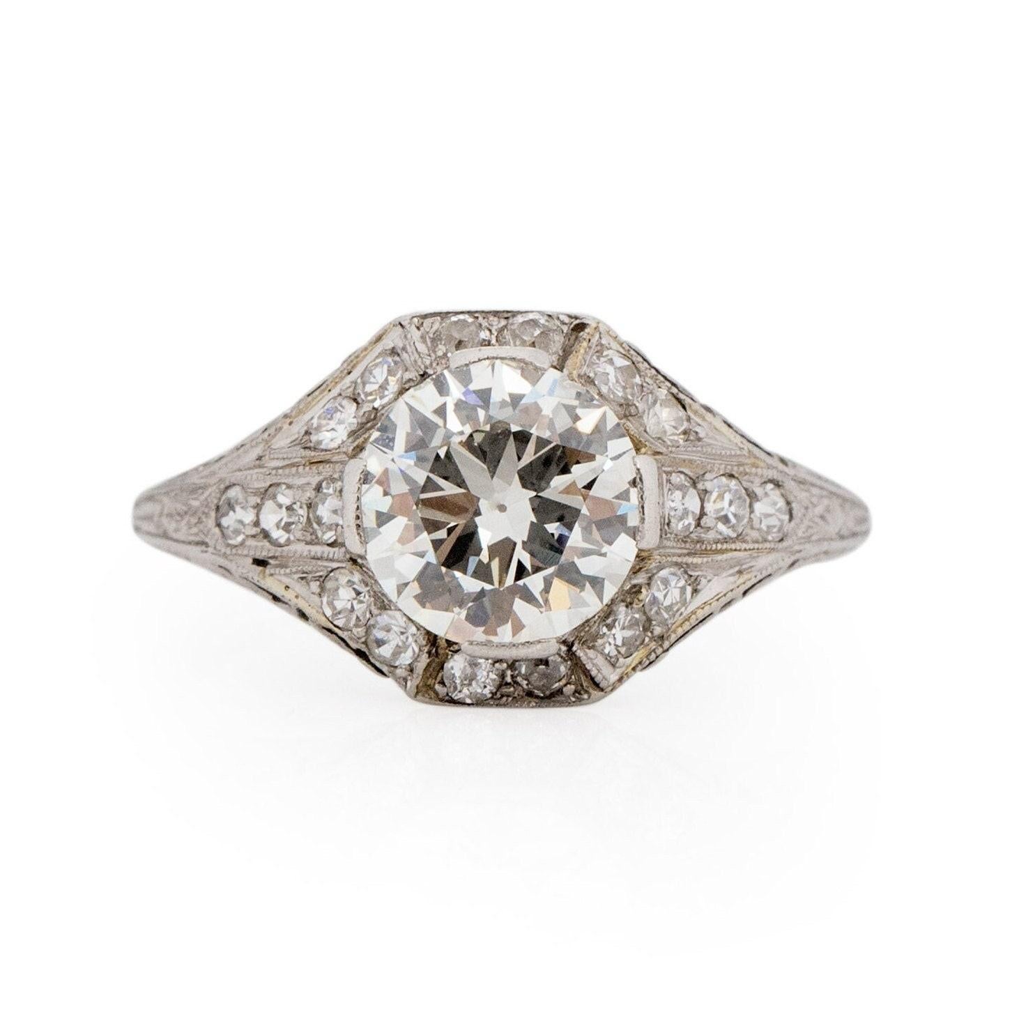 Behold this captivating Art Deco masterpiece, a breathtaking embodiment of style. It's becoming increasingly challenging to find rings with diamonds of this size and quality. The centerpiece features a magnificent 1.55 Ct Old European cut diamond