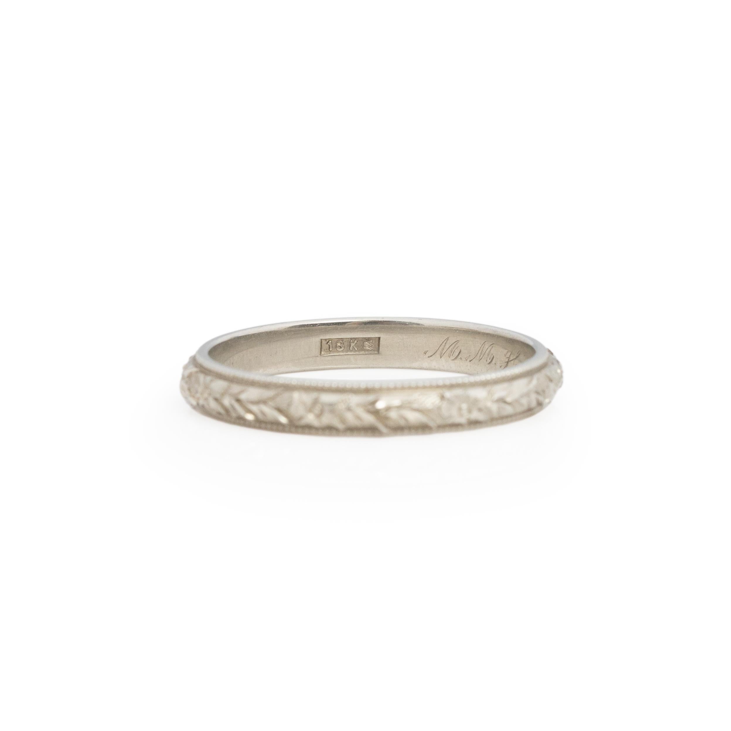 This 18K white gold wedding band is in outstanding condition. The Floral engraving is crisp and clean, from the flower details to each vein in the leaves encompassing the ring. Each carved stroke done with purpose; ending is a stunning floral