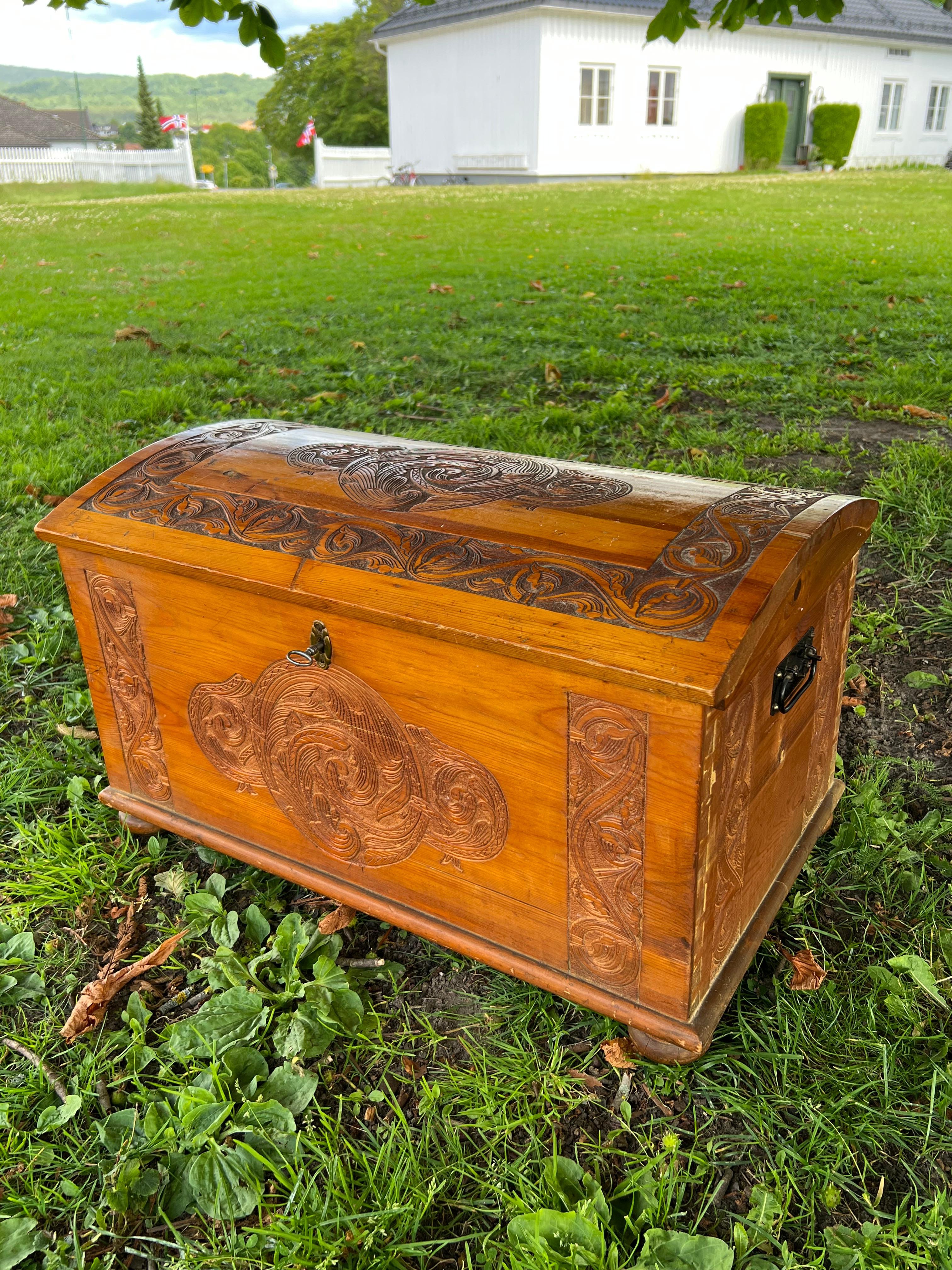 1940s Norwegian Handcrafted Pine Trunk

This exquisite solid pine trunk, crafted in 1942, features intricate dragon-style carvings and acanthus vine motifs—hallmarks of traditional Norwegian folk art. Attributed to Magnus Dagestad, it includes its