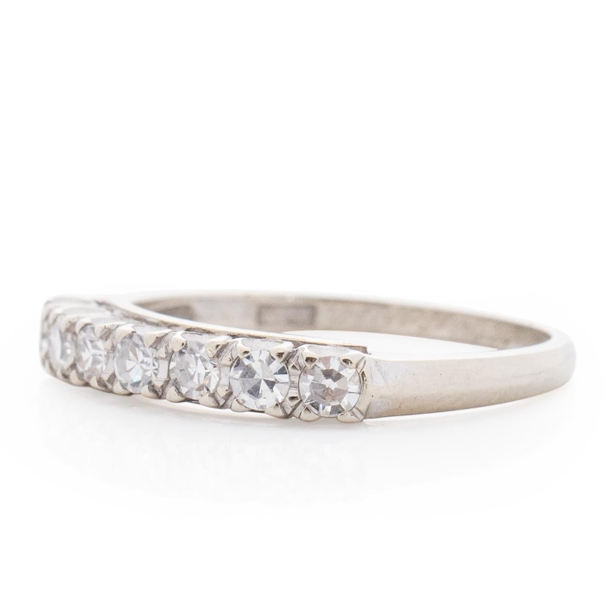 This ring is a classic beauty. Simple and elegant and a perfect ring to pair up with a vintage engagement ring. Crafted in 14K white gold this fish tail style mount holds 7 vibrant diamonds. This ring would also look great stacked with other vintage