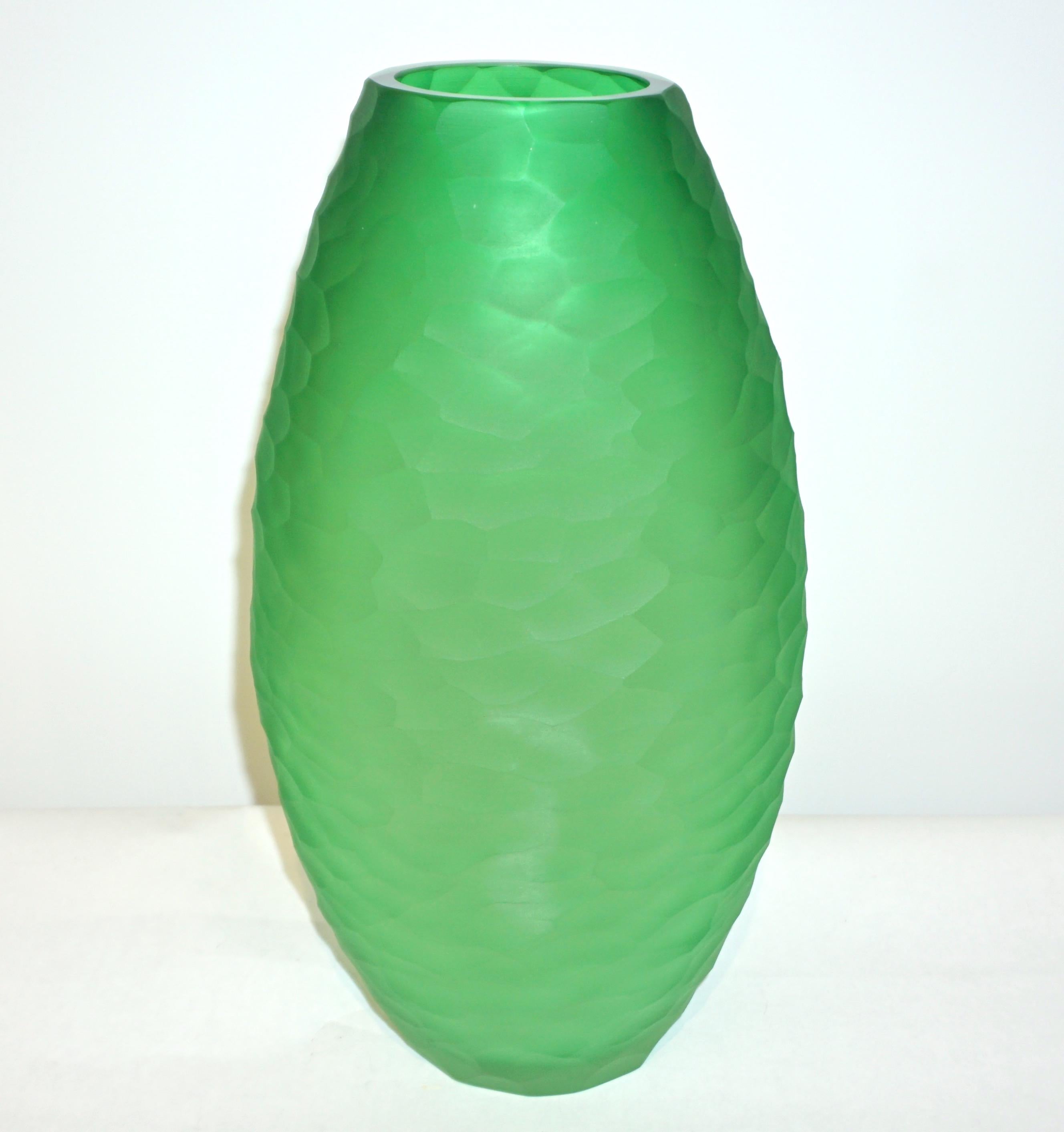 An elegant vase of ovoid shape, in a chic vivid green Murano glass, blown by Vivarini, with a high quality of decoration in a precious small battuto on the entire surface, hand chiseled while the glass is still hot, executed by the artist Schiavon.