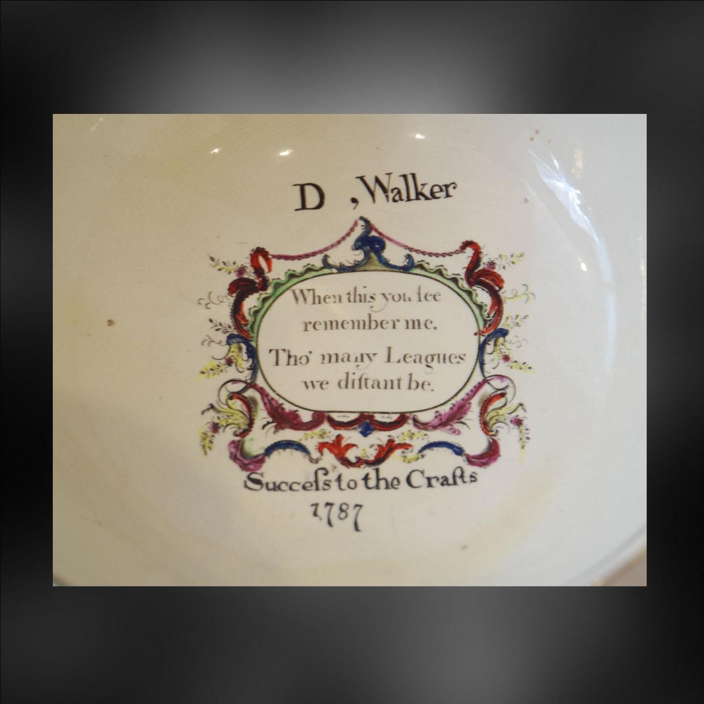 A documentary punch bowl, decorated with transfer prints and enameling, dated and inscribed for D. Walker. Unmarked, but this class of dated creamware with enameled prints belongs to Leeds.

