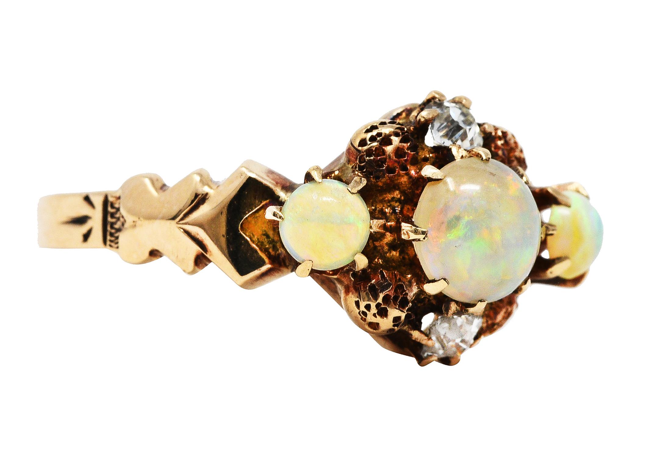 Cluster style ring designed with stylized head and shoulders

Centering one 5.0 mm and two 3.0 mm round cabochon opals in belcher settings

Opals are translucent and white in body color with strong blue/green play of color

Featuring two old mine