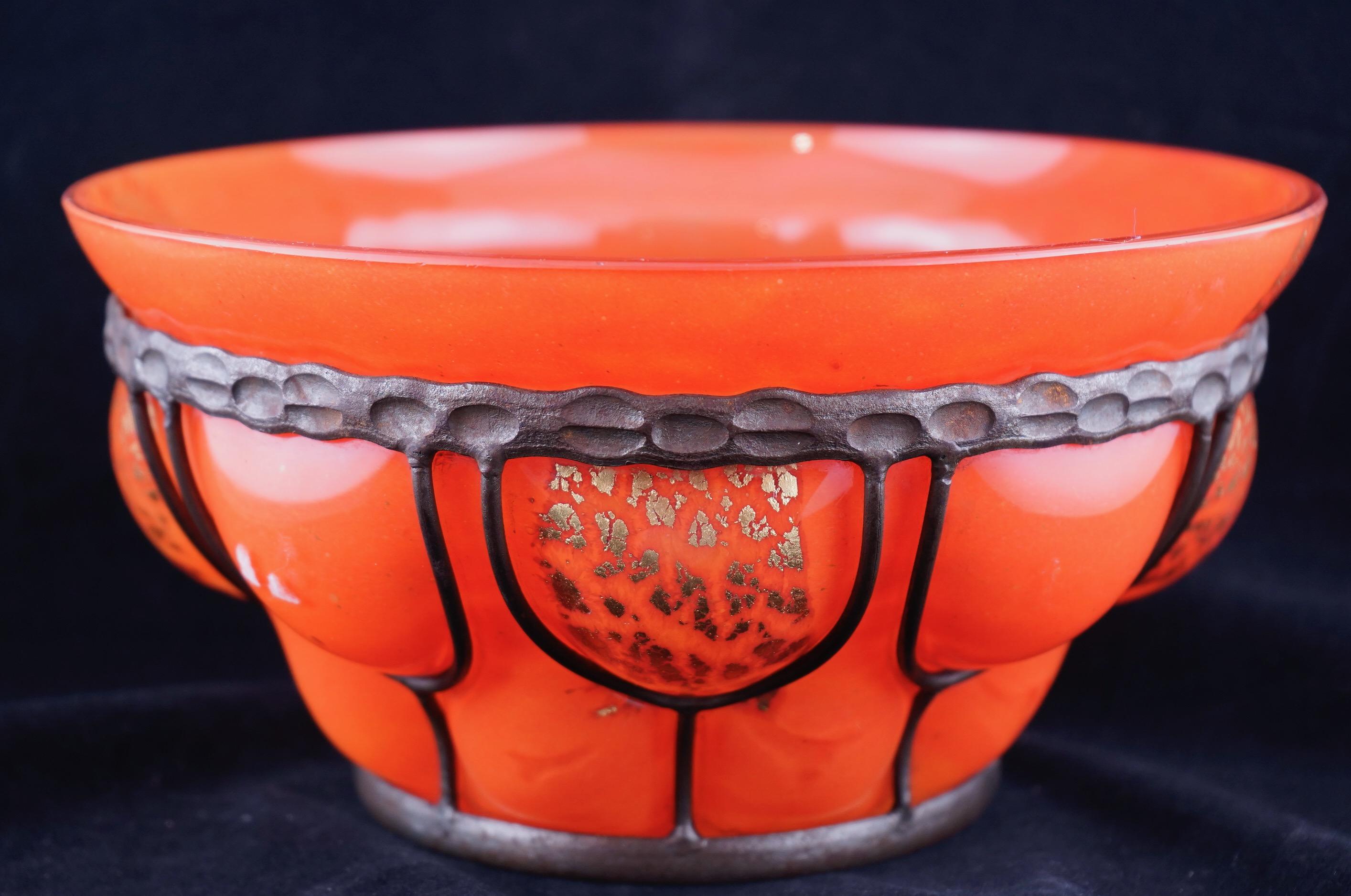 Daum and Majorelle glass bowl blown into a wrought iron frame. The glass is bright orange with gold foil inclusions. The bowl is engraved on the bottom with the makers' signatures.