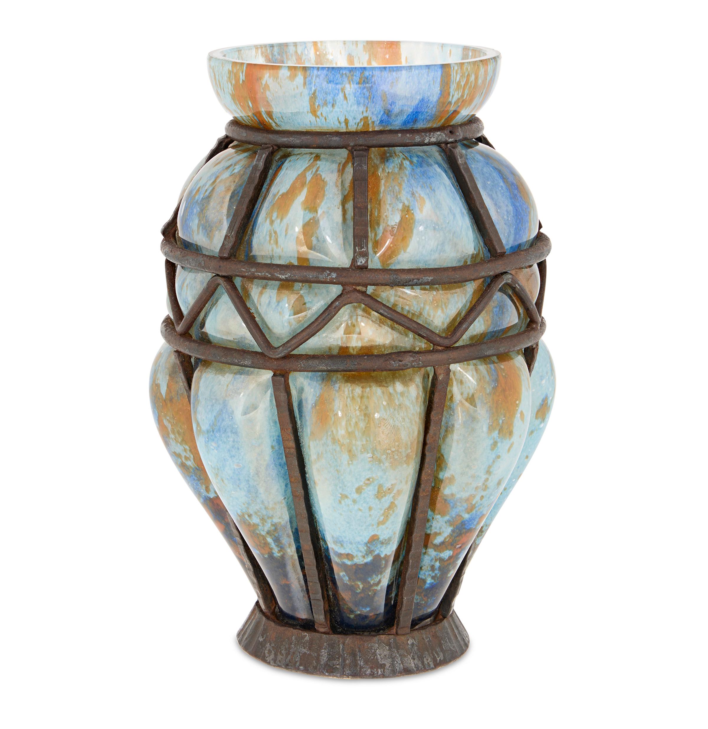 Blaue und orangefarbene Glasvase mit schmiedeeisernem Rahmen
Daum Nancy und Majorelle
CIRCA 1925

Diese bemerkenswerte Vase zeigt die gemeinsame Kunstfertigkeit von Daum Nancy und Louis Majorelle, zwei der einflussreichsten Persönlichkeiten der